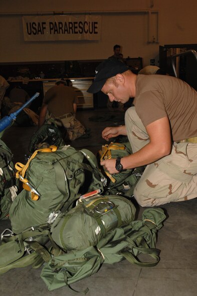 Senior Airman Ryan Ruddy configures his static line parachute for a night jump August 5.  Airman Ruddy is a pararescueman from the 48th Rescue Squadron.  (U.S. Air Force photo by Senior Airman Alesia Goosic)