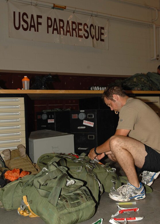 Senior Airman Ryan Ruddy configures his static line parachute for a night jump August 5.  Airman Ruddy is a pararescueman from the 48th Rescue Squadron.  (U.S. Air Force photo by Senior Airman Alesia Goosic)