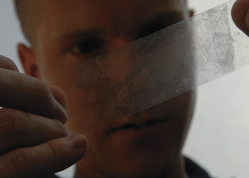 Special Agent Bryan Schmelzer, Forensic Science Consultant, 2nd Field Investigations Squadron, Air Force Office of Special Investigations Region 7, looks at a fingerprint pulled from evidence during a training scenario here July 17. (U.S. Air Force photo/Senior Airman Steven R. Doty) 