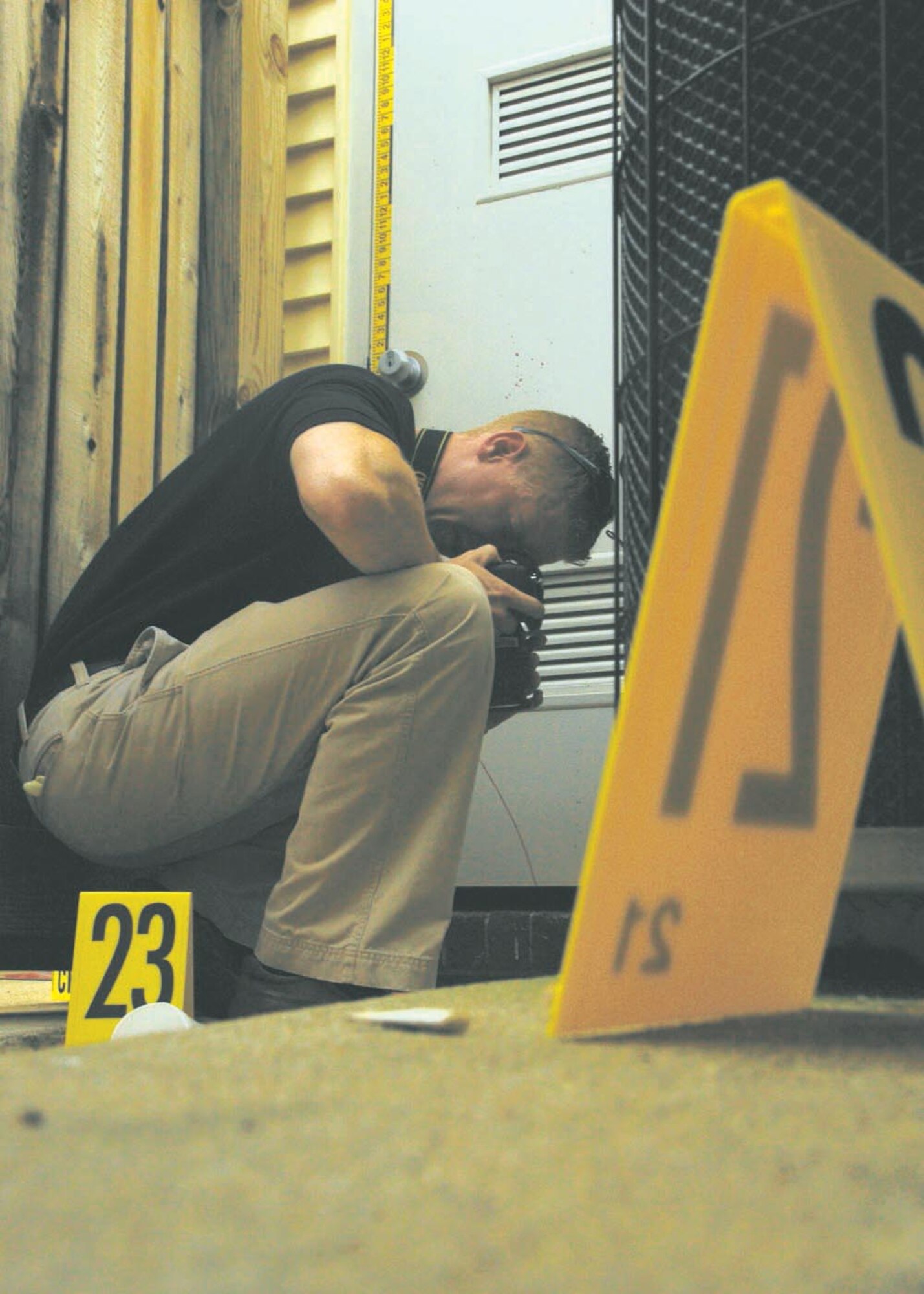 Special Agent Bryan Schmelzer, Forensic Science Consultant, 2nd Field Investigations Squadron, Air Force Office of Special Investigations Region 7, photographs evidence during a training scenario. The training scenarios help prepare agents to collect evidence during investigations. (U.S. Air Force photo/Airman 1st Class Melissa Rodrigues) 