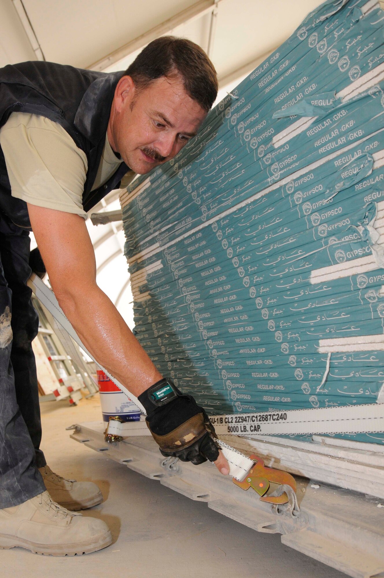 Tech. Sergeant Joseph Zeigler, yard boss with the 1st Expeditionary Rapid Engineer Deployable Heavy Operational Repair Squadron Engineers (RED HORSE) Group, secures the strap of a pallet Aug. 11, 2008, at an undisclosed air base in Southwest Asia. Sergeant Zeigler secures the pallet to ensure that all the items reach the troops undamaged. The 1st Expeditionary RED HORSE Group performs heavy repair and construction projects throughout the US Central Command’s area of responsibility. Sergeant Zeigler, a native of Tallahassee, Fla., is deployed from Hurlburt Field, Fla., in support of Operations Iraqi Freedom, Enduring Freedom and Joint Task Force-Horn of Africa. (U.S. Air Force photo by Staff Sgt. Darnell T. Cannady/Released)