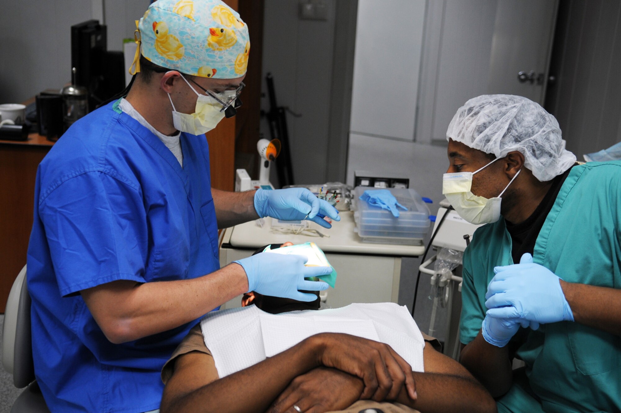07/30/2008 - MANAS AIR BASE, KYRGYZ REPUBLIC -- Capt. Zachary Allmand (left) and Tech. Sgt. Paul Brown, operating room surgery technician, perform a root canal on a patient here, July 30, in the new 376th Expeditionary Medical Group medical facility. (Air Force photo / Airman 1st Class Ruth Holcomb)