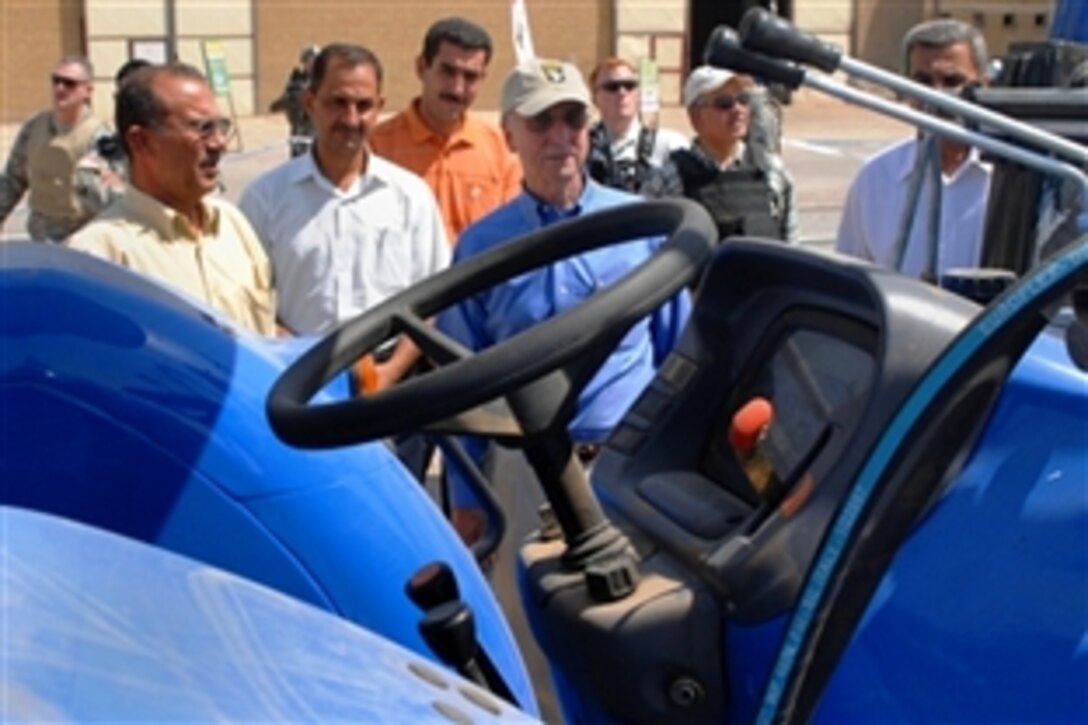 Gordon England, U.S. deputy defense secretary, center, looks at a tractor manufactured at the Iskandariyah Industrial Complex on Forward Operating Base Kalsu, Iraq, during his visit to the facility, Aug. 9, 2008.


