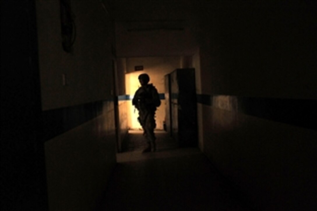 U.S. Army Spc. Alex Bednarowski patrols the halls of an Iraqi police station in the Sadr City district of Baghdad, Iraq, Aug. 7, 2008. Bednarowski, assigned to the 432nd Civil Affairs Battalion, is assessing the school as part of a plan to revitalize Sadr City. 
