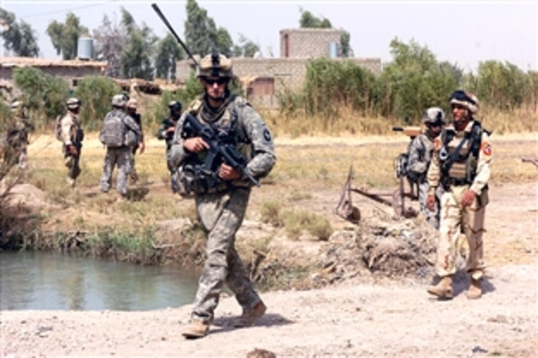 U.S. Army Pfc. Mark Vero and Iraqi army soldiers search farmhouses in southern Muehla during Operation Dodge City II, Aug. 4, 2008. Vero is assigned to the 3rd Infantry Division's 2nd Battalion, Company D, 502nd Infantry Regiment. 