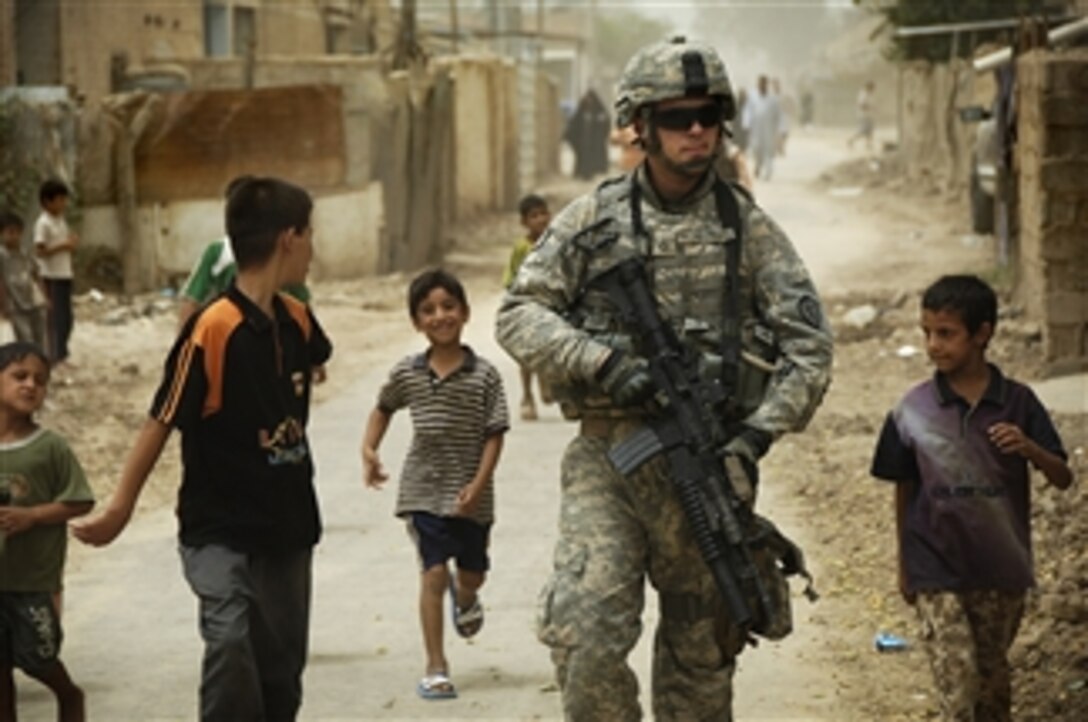 Iraqi children gather around as U.S. Army Pfc. Shane Bordonado patrols the streets of Al Asiriyah, Iraq, on Aug. 4, 2008.  Bordonado is assigned to 2nd Squadron, 14th Cavalry Regiment, 25th Infantry Division.  
