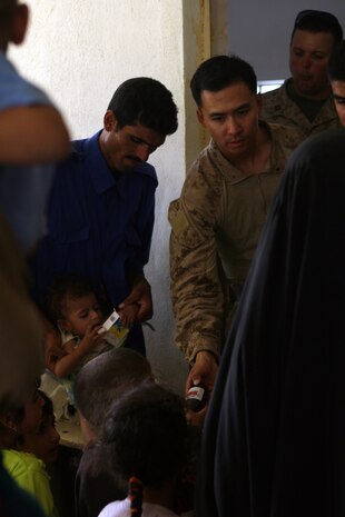 Navy Lt. Liu, battalion surgeon, 2nd Battalion, 3rd Marine Regiment, Regimental Combat Team 1, passes out prescribed medicine to Iraqis in Subyhat, Iraq during a cooperative medical engagement Aug. 12. The Island Warriors helped approximately 1,000 Iraqis by giving them medical treatment during the two-day event.