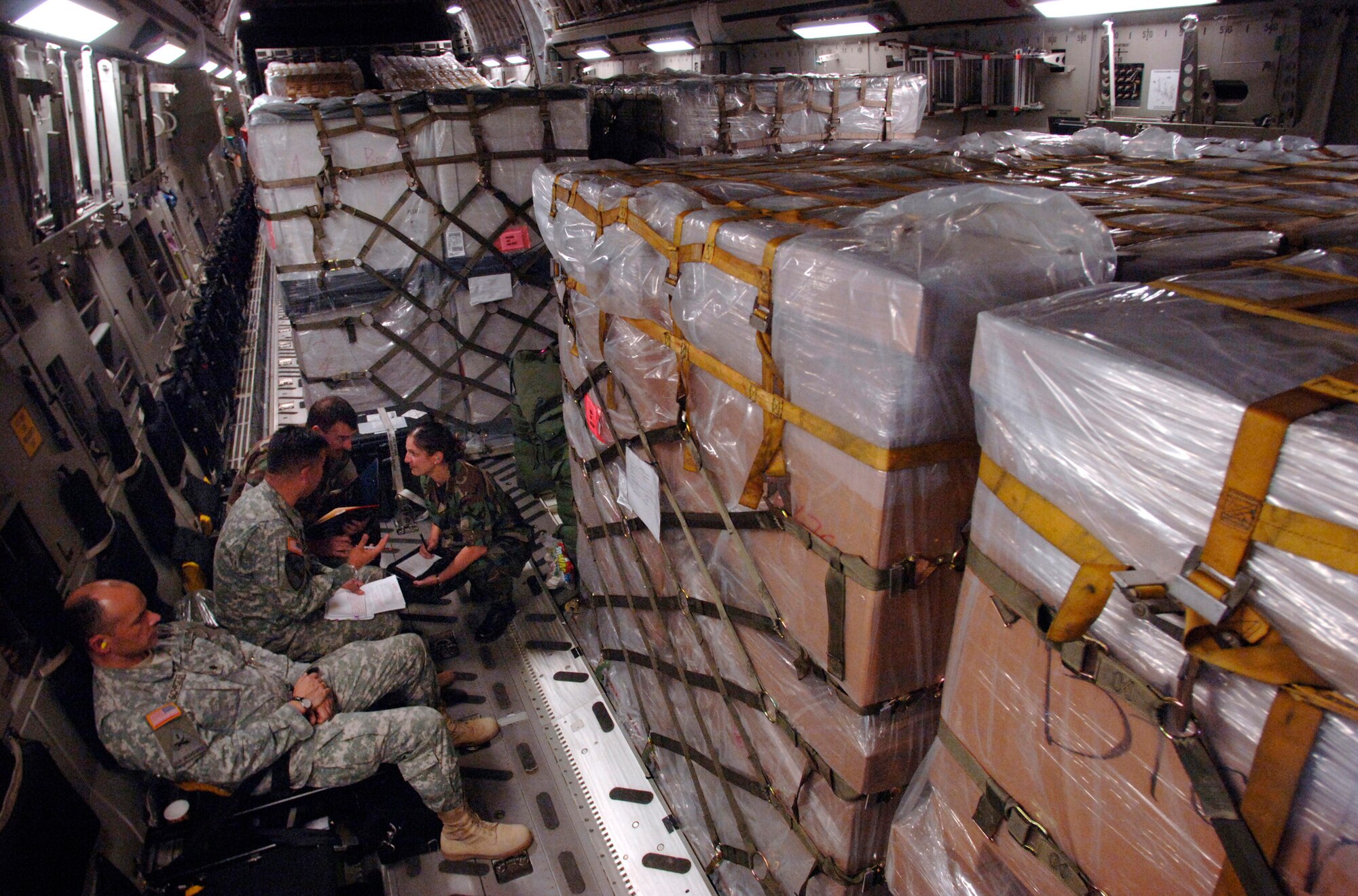 While en route to Tbilisi, Georgia, from Ramstein Air Base, Germany, a small group of U.S. Army, Navy and Air Force officers discuss details of the joint humanitarian assistance delivery. The delivery consisted of $1 million in U.S.-donated medical supplies, blankets, sleeping bags and bed sheets for the people of the Republic of Georgia. (U.S. Air Force photo/Master Sgt. Scott Wagers)