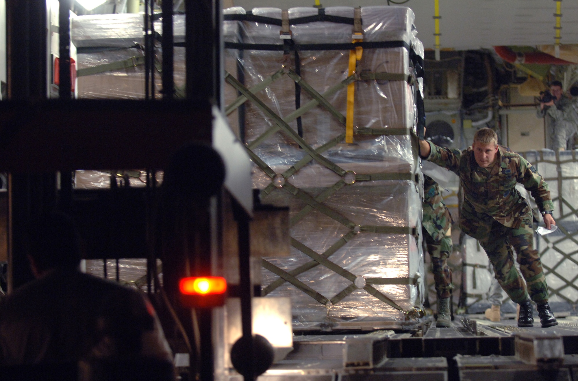 Aerial transporter Staff Sgt. Chris Broegemueller, assigned to the 86th Airlift Wing's Contingency Response Group at Sembach Air Base, Germany, helps push out the first of 16 pallets aboard an Air Force C-17 Globemaster III today. The humanitarian assistance delivery consisted of $1 million in U.S.-donated medical supplies, blankets, sleeping bags and bed sheets for the people of the Republic of Georgia. The delivery was a joint service effort between Airmen representing both U.S. Air Forces in Europe and Air Mobility Command, as well as U.S. Army Europe Soldiers. (U.S. Air Force photo/Master Sgt. Scott Wagers)
