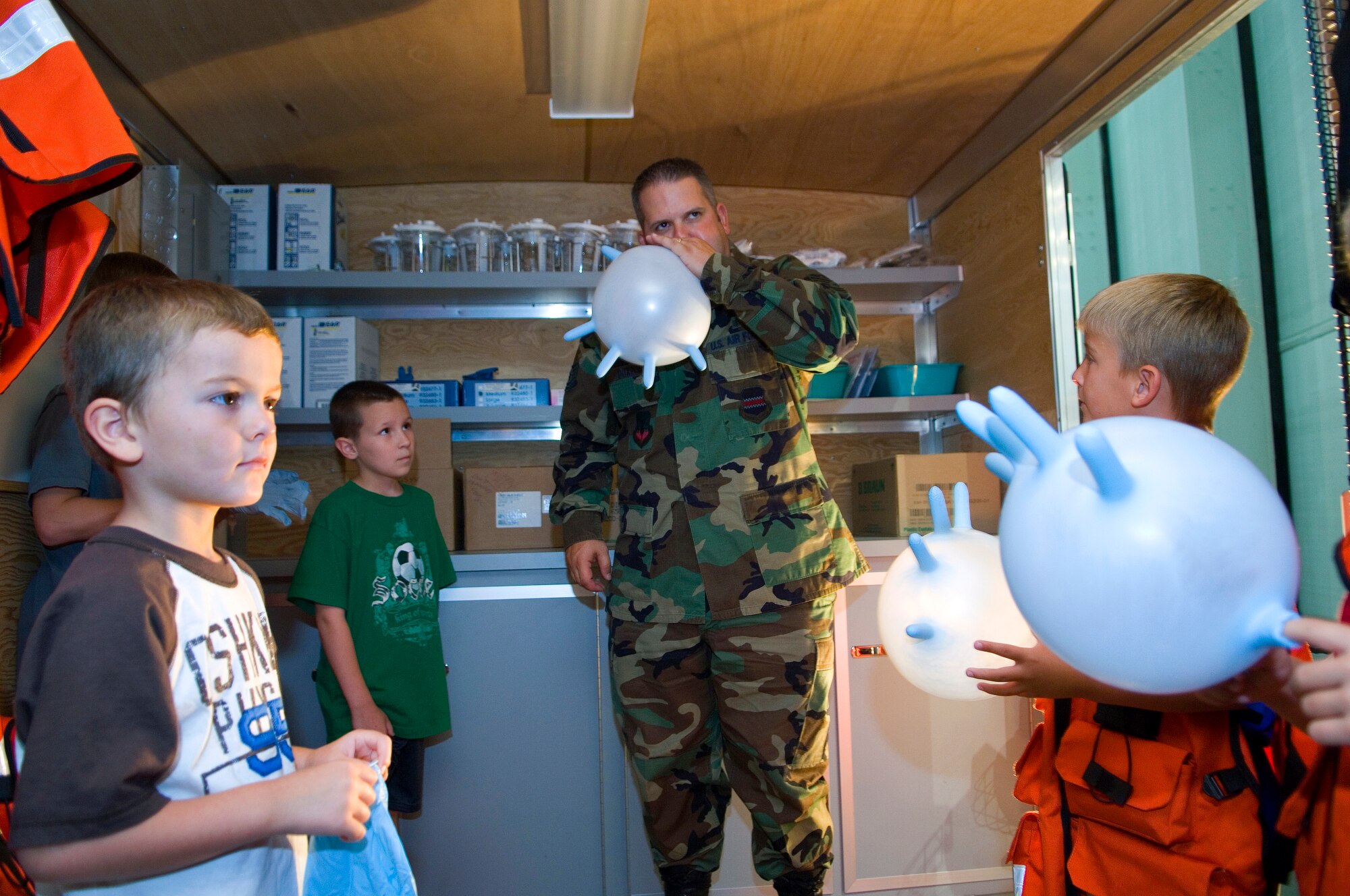 Tech. Sgt. Shane Doxdon makes glove balloons for children visiting the Strategic Air and Space Museum during Air Force Week in the Heartland Aug. 13 in Ashland, Neb. Museum officials hosted a day dedicated to the legacy of airpower providing special Air Force demonstration teams and displays. Sergeant Doxdon is a member of the 55th Medical Group from Offutt Air Force Base, Neb. (U.S. Air Force photo/Staff Sgt. Bennie J. Davis III)