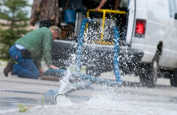 Denis Murphy a Davis, Gonzalez, and Rodriguez maintenance employee pumps water out of a flooded utilidor Aug. 7 at Eielson AFB. Eielson received more rainfall in the past couple weeks than it receives all year. With this much rain fall in a short amount of time the local area is experiencing mass flooding; there are currently more than 65 homes that have up to six inches of water in their basements. The DGR housing maintenance office is working on restoring all basements that have water damage. (U.S. Air Force photo by Airman 1st Class Jonathan Snyder) (Released) 