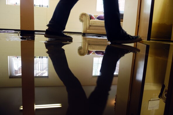 Capt. Tammy Colvin walks across her basement floor covered with water as she moves items from the basement to higher ground Aug. 7 at  Eielson AFB.  Eielson received more rainfall in the past couple weeks than it receives all year. With this much rain fall in a short amount of time the local area is experiencing mass flooding; there are currently more than 65 homes that have up to six inches of water in their basements. The Davis, Gonzalez, and Rodriguez housing maintenance office is working on restoring all basements that have water damage. Captain Colvin is assigned to the 354th Fighter Wing Comptroller Squadron. (U.S. Air Force photo/Airman 1st Class Jonathan Snyder) 
