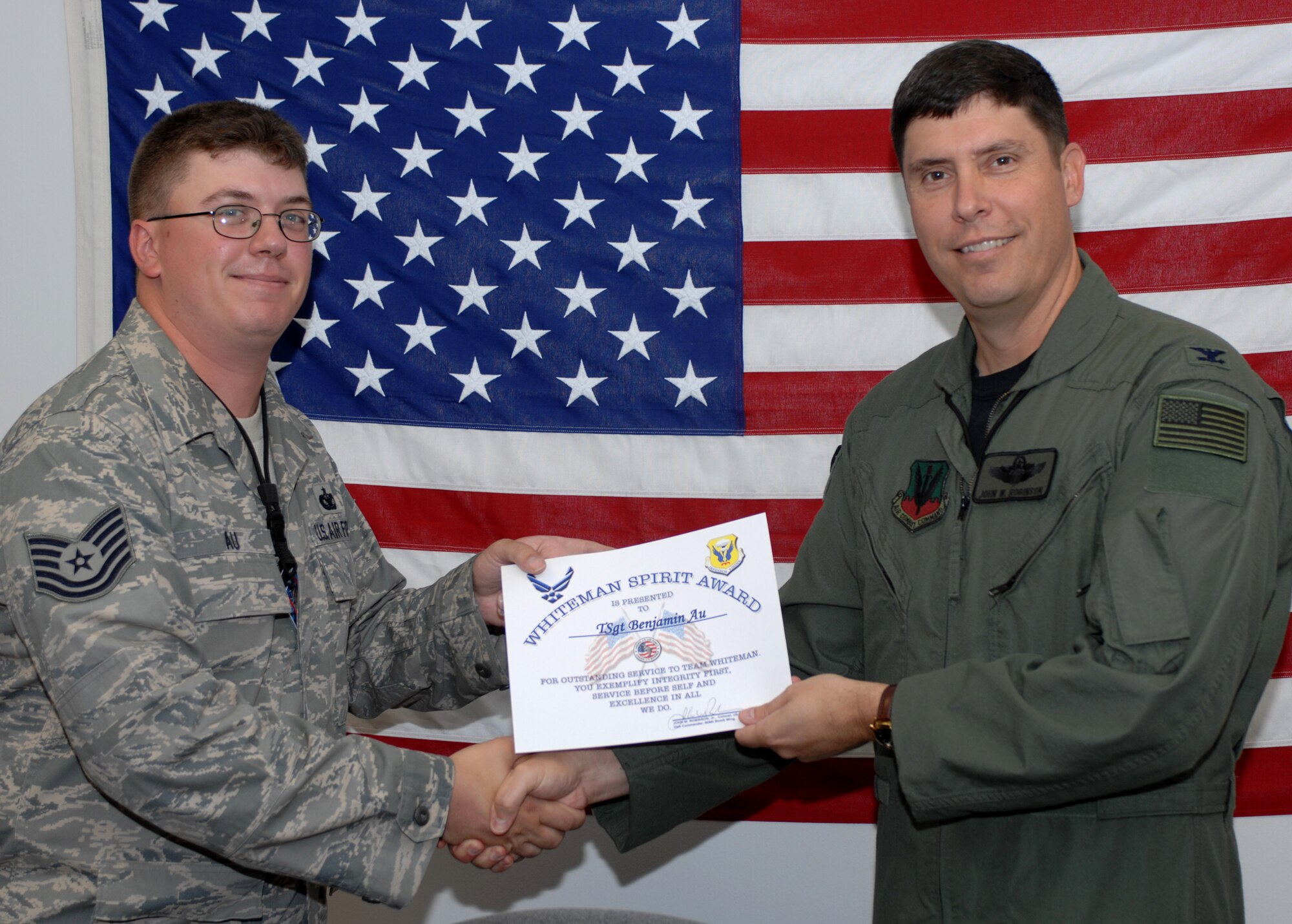 WHITEMAN AIR FORCE BASE, Mo., -- Col. John Robinson (right), 509th Bomb Wing vice commander, presents Tech. Sgt. Ben Au, 509th Bomb Wing program security manager, with the Whiteman Spirit Award Aug. 6. 