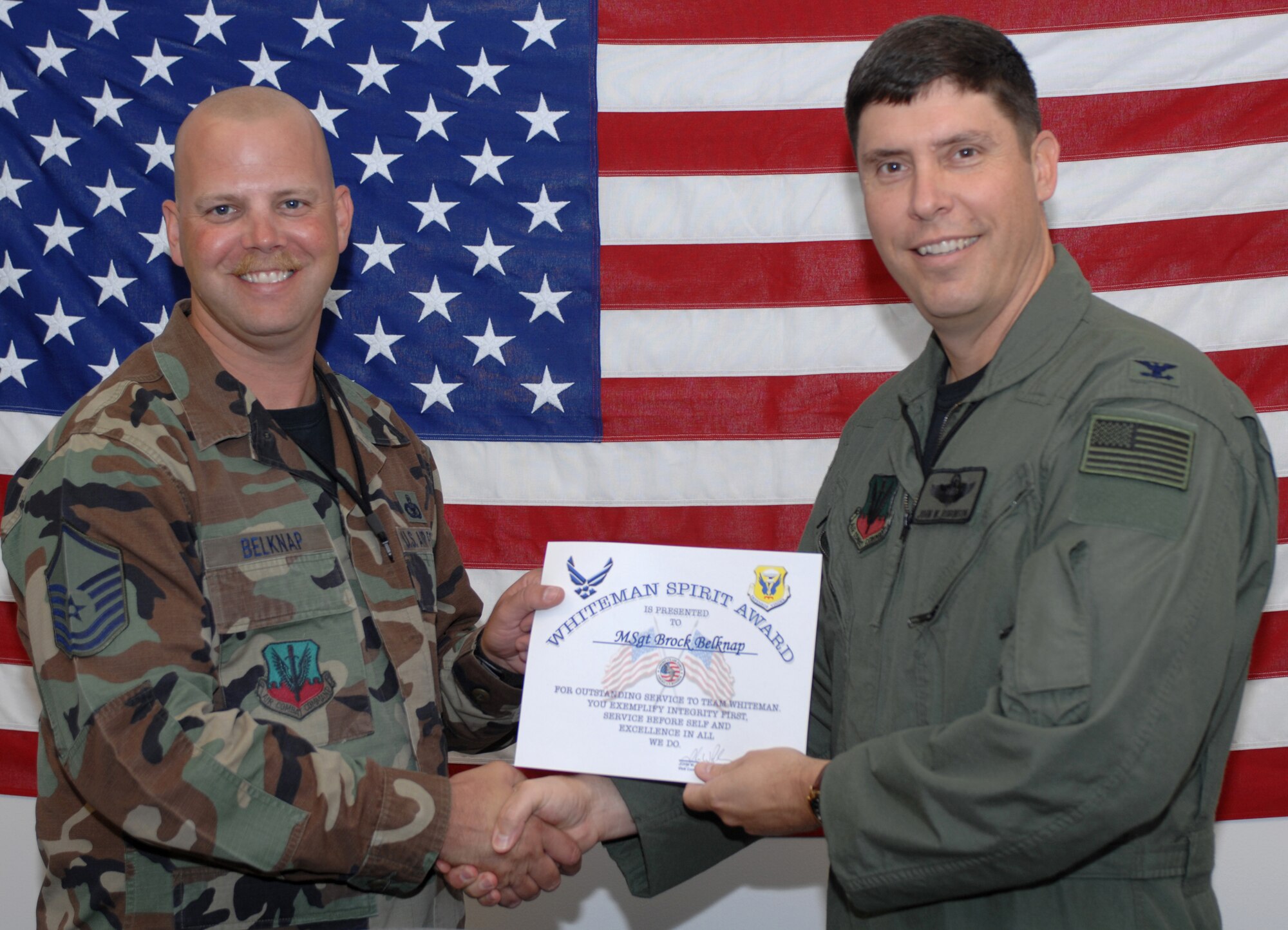 WHITEMAN AIR FORCE BASE, Mo., -- Col. John Robinson (right), 509th Bomb Wing vice commander, presents Master Sgt.Brock Belknap, 509th Bomb Wing program security manager, with the Whiteman Spirit Award Aug. 6. 