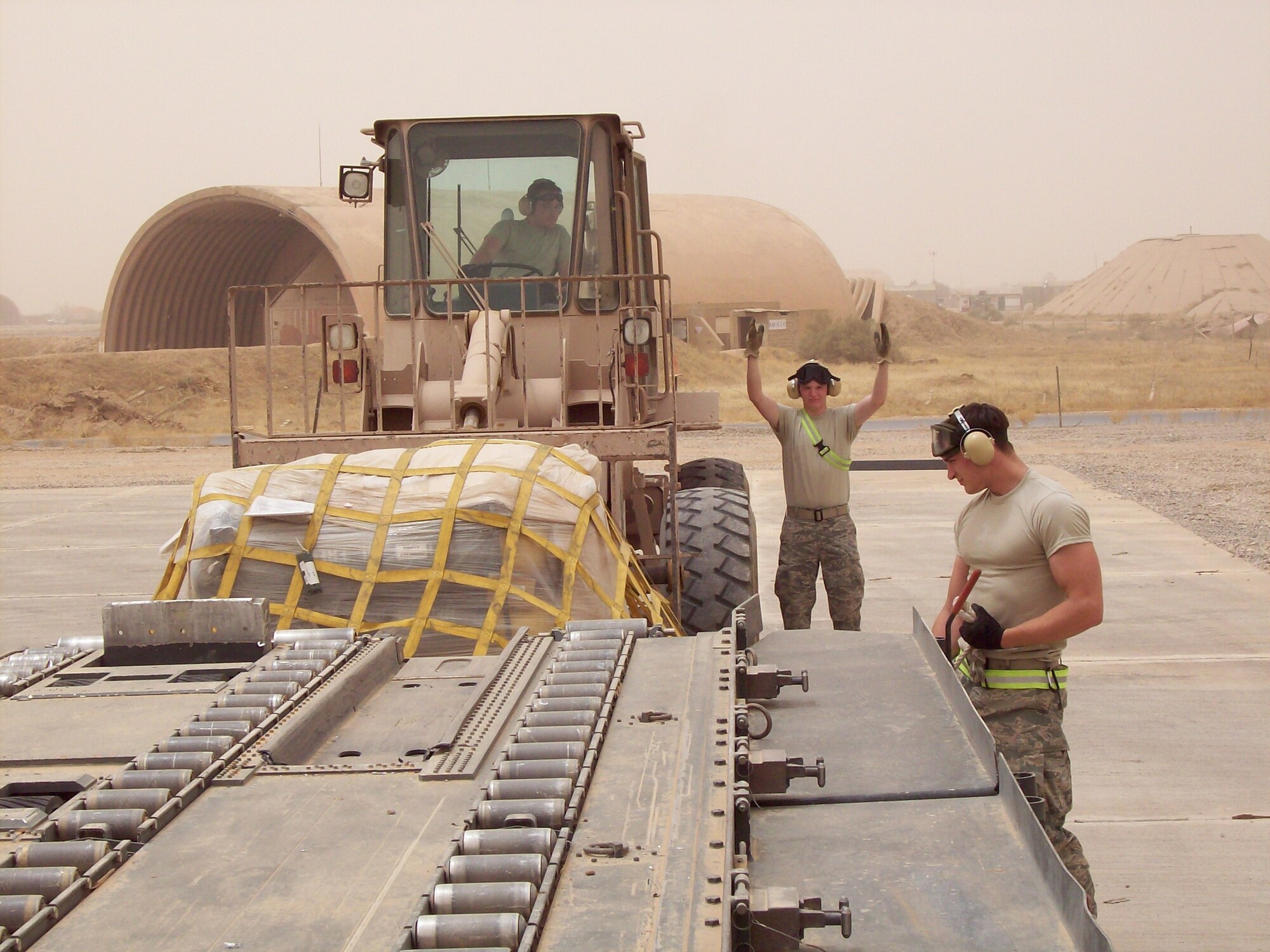 IRAQ — Airman 1st Class Joshua Boylan (driving), Airman 1st Class Jeremy Schmid(spotting) and Airman 1st Class Donald Kraft (chalking), all 62nd Aerial Port Squadron, set up a cargo pallet during a recent deployment. (Courtesy photo.)