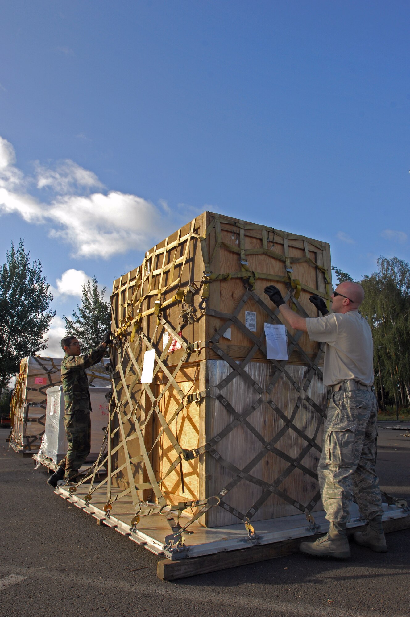 Airman 1st Class Rogelio Munoz and Tech. Sgt. Warren Parson prepare cargo heading to the country of Georgia Aug. 13 at Ramstein Air Base, Germany. Both Airmen are assigned to the 435th Logistics Readiness Squadron. (U.S. Air Force photo/Airman 1st Class Kenny Holston)