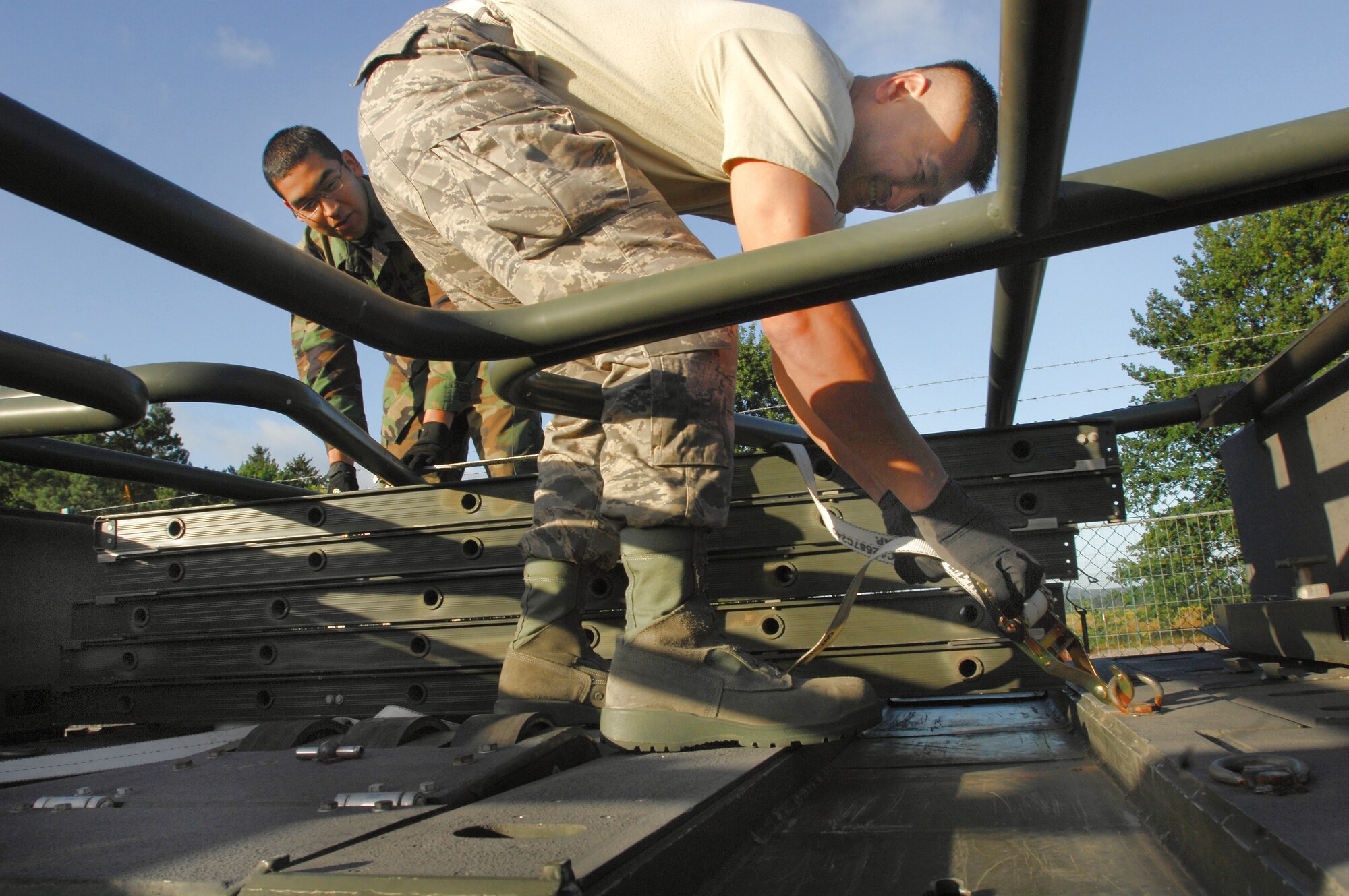 Master Sgt. Seksun Monroe (right) and Airman 1st Class Rogelio Munoz prepare cargo heading to the country of Georgia Aug. 13 at Ramstein Air Base, Germany. Both Airmen are assigned to the 435th Logistics Readiness Squadron. (U.S. Air Force photo/Airman 1st Class Kenny Holston)