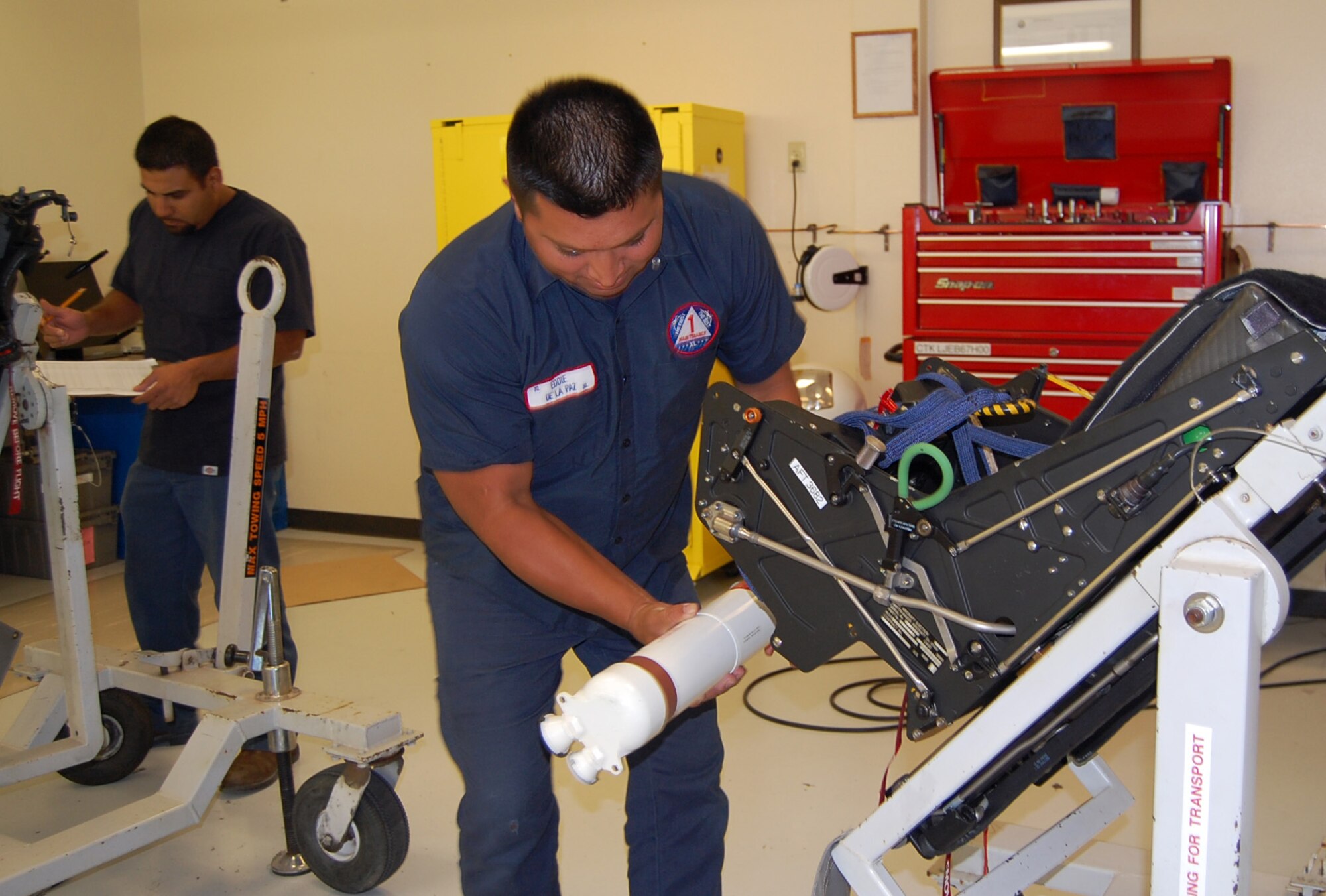 LAUGHLIN AIR FORCE BASE, Texas-- Eddie De La Paz affixes an explosive device to the ejection seat of a T-6 Texan II at the Egress shop here Aug. 7.  De La Paz is a member of the 47th Maintenance Directorate’s Aircraft Ordnance Systems shop.  Members of the shop are responsible for performing maintenance work on aircraft ejection seats. They are also responsible for maintaining complete emergency escape systems, such as ejection seats, escape hatches and capsules, used by flight personnel to escape disabled aircraft.  (U.S. Air Force photo/Staff Sgt. Olufemi A. Owolabi)