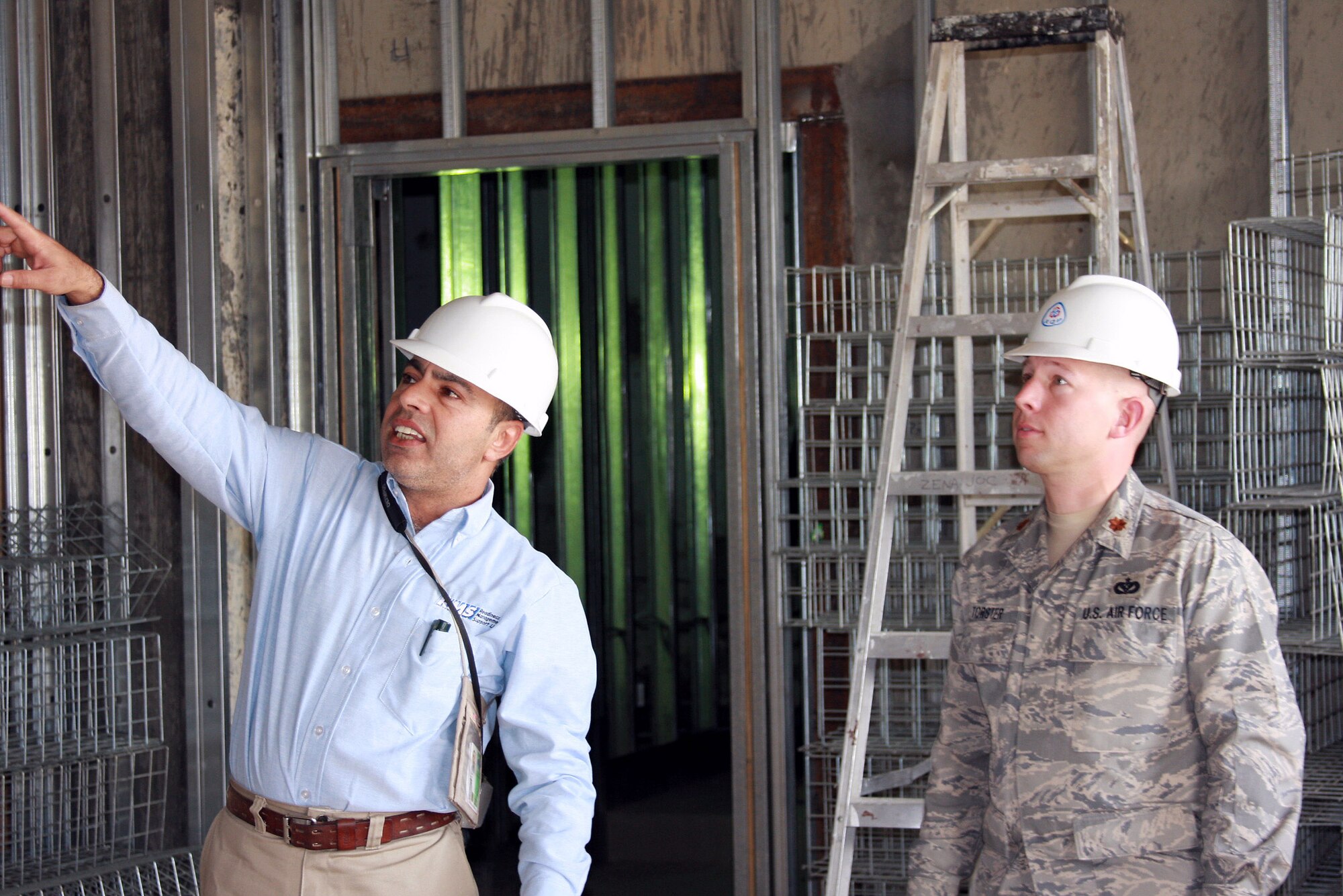 A civilian contractor shows Maj. Kyle Torster the progress of a current construction progress under way on the Afghanistan-based airfield. Of the many ongoing projects, a new $2.7 million Combined Joint Task Force-101 administrative building is nearing completion. Major Torster is a Bagram Airfield facility engineer team member. (Courtesy photo) 