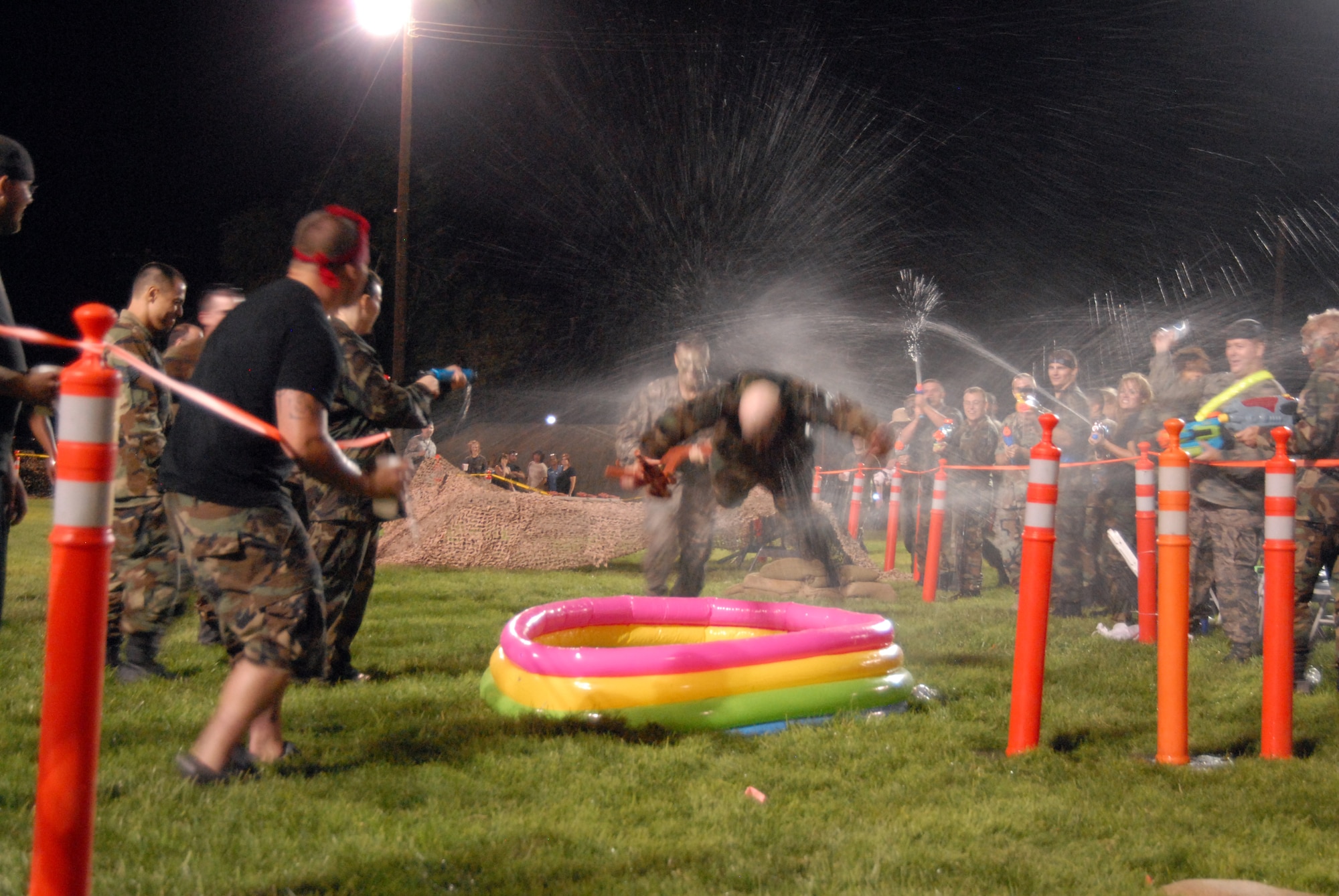 An Airman dives headfirst into a "pit" while evading water counterattack during a combat dining out at Edwards' Arnold Park Aug. 8. A combat dining out is a formal military function that brings together units from across the base in an attempt to build camaraderie and social networking. (Air Force photo by Airman 1st Class William O'Brien)