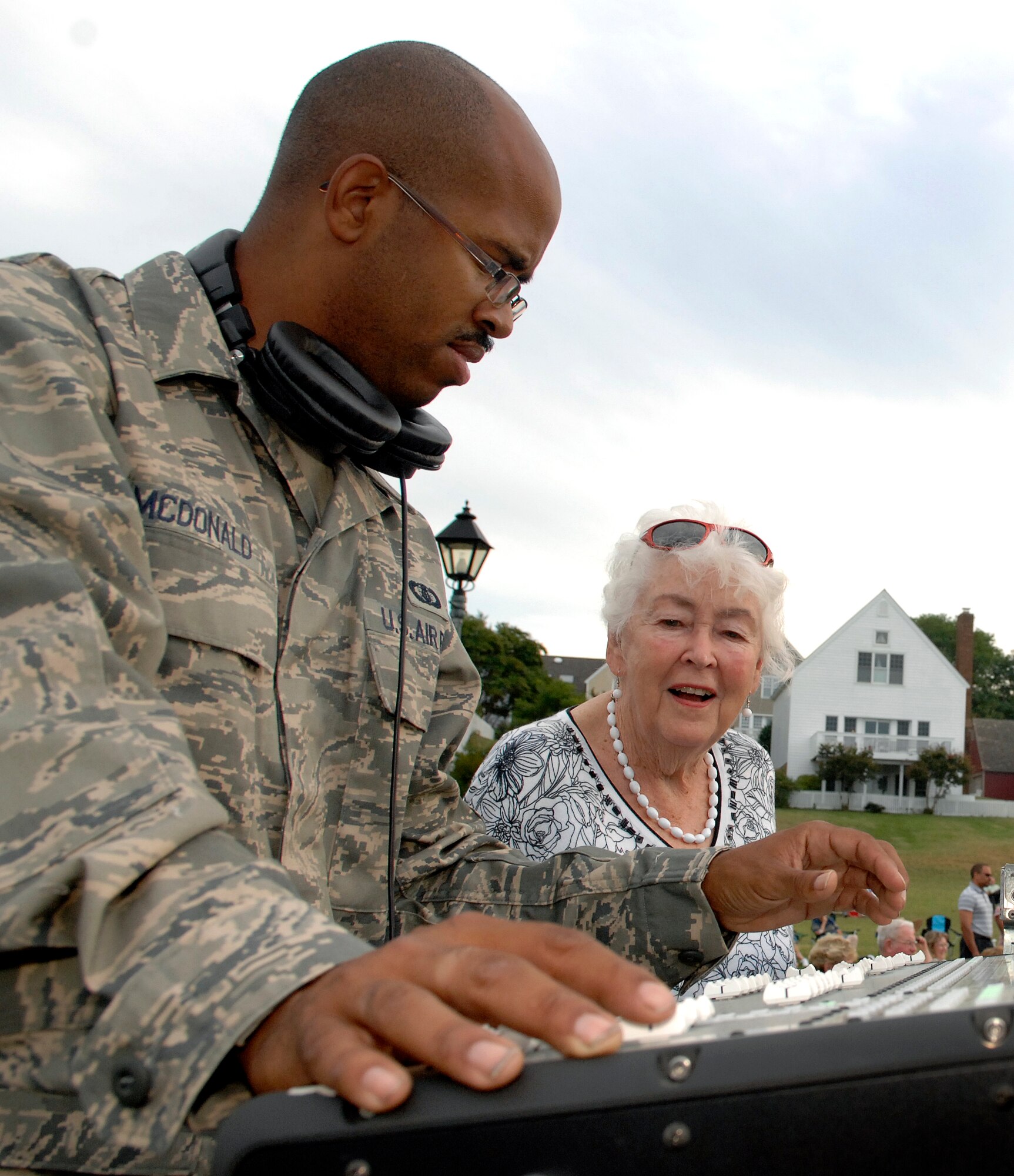 LANGLEY AIR FORCE BASE, Va. -- Senior Airman Kelcey McDonald, Air Combat Command Heritage of America Band sound technician, explains the mechanics of the sound board to a woman of Yorktown, Va. during a concert Aug. 12.  The ACC Heritage of America Band performs during the summer months to connect with the local community and is scheduled to perform in Yorktown again Aug. 19.  (U.S. Air Force photo/Senior Airman Vernon Young)