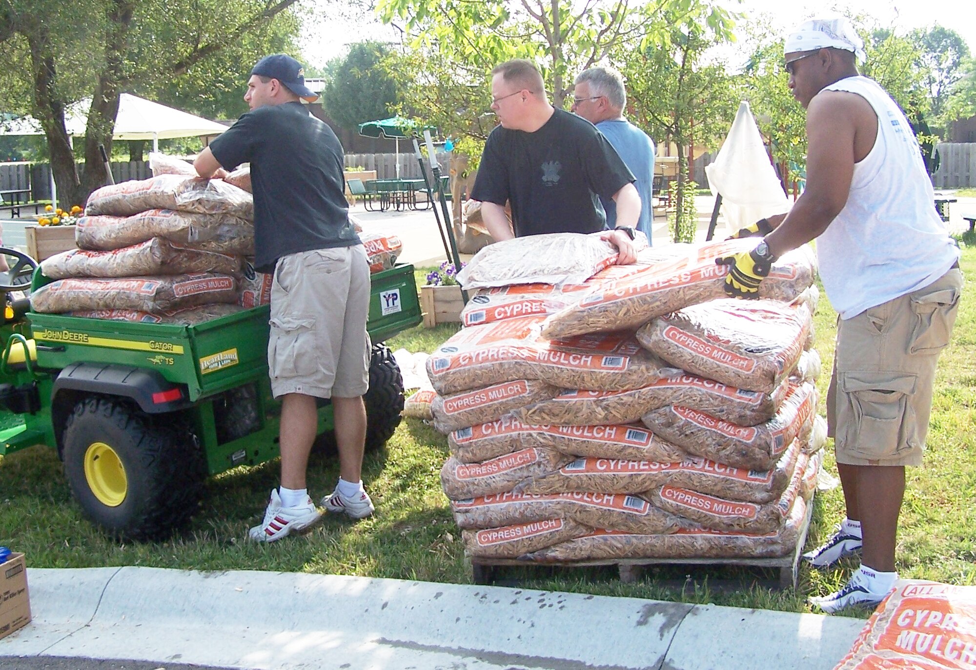 WHITEMAN AIR FORCE BASE, Mo. - (left to right) Lt. Andy Zanrucha, 509th Maintenance Group, Maj. Mark Lynch, 509th Logistics Readiness Squadron comander, Doug Kermick and Capt. Mike Boswell, 509th Bomb Wing, unload mulch to be used for planting trees at the Youth Center July 26. The CGOC is a professional development organization comprised of lieutenants and captains. Volunteers from the CGOC spent the day cleaning up the Youth Center grounds by mowing, shoveling, sweeping and mulching the grounds where appropriate. (Photo courtesy 2nd Lt. Amy Blanco)