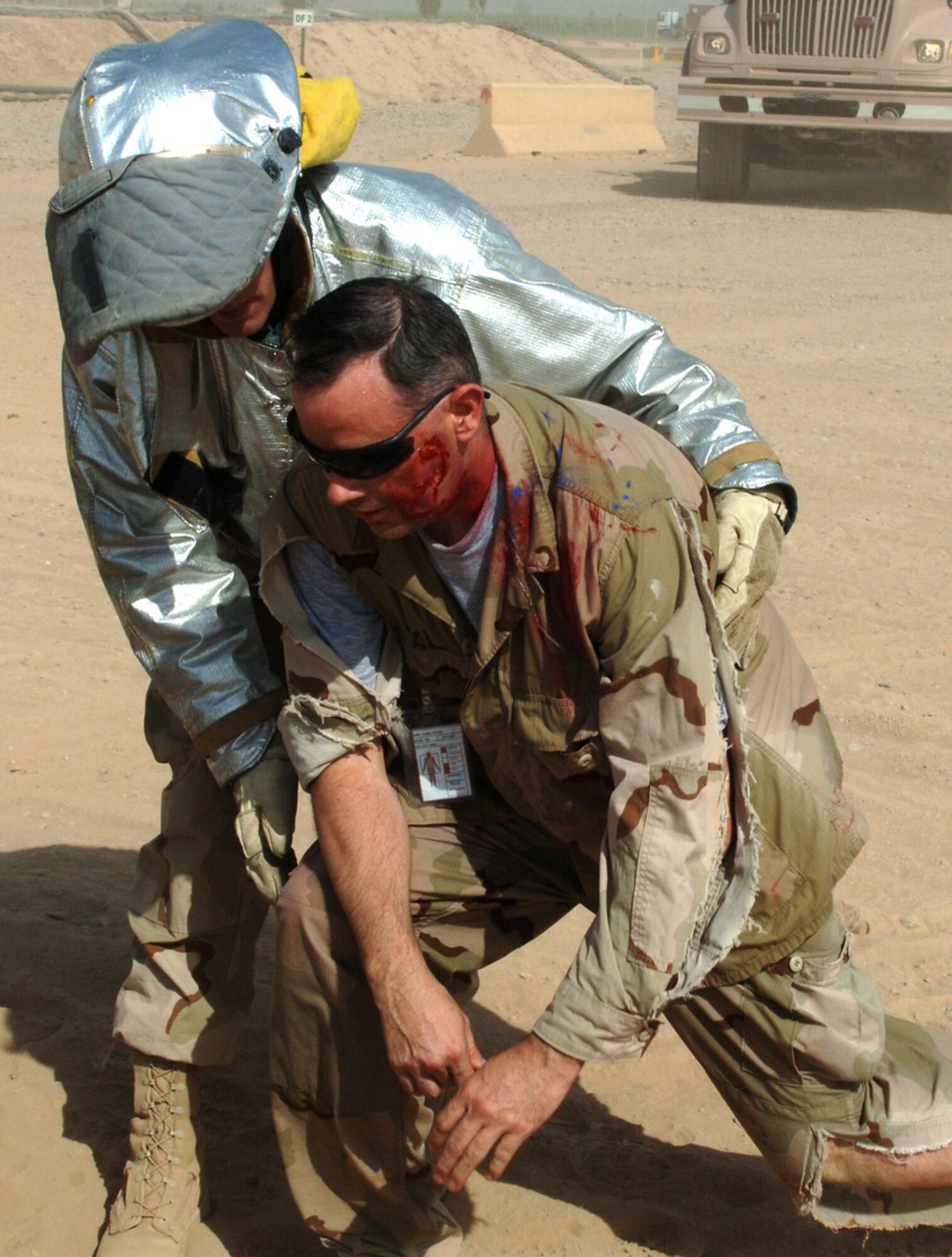 JOINT BASE BALAD, Iraq -- Airman 1st Class Troy  Falkena assists injured participants during a Mass Accident Response Exercise here Aug. 11. More than 100 Airmen and Soldiers participated in the joint exercise, ensuring that first responders are ready for any situation at any time. Airman Falkena, a firefighter with the 332nd Expeditionary Civil Engineer Squadron here, is deployed from Langley Air Force Base, Va. (U.S. Air Force photo/Tech. Sgt. Richard Lisum)