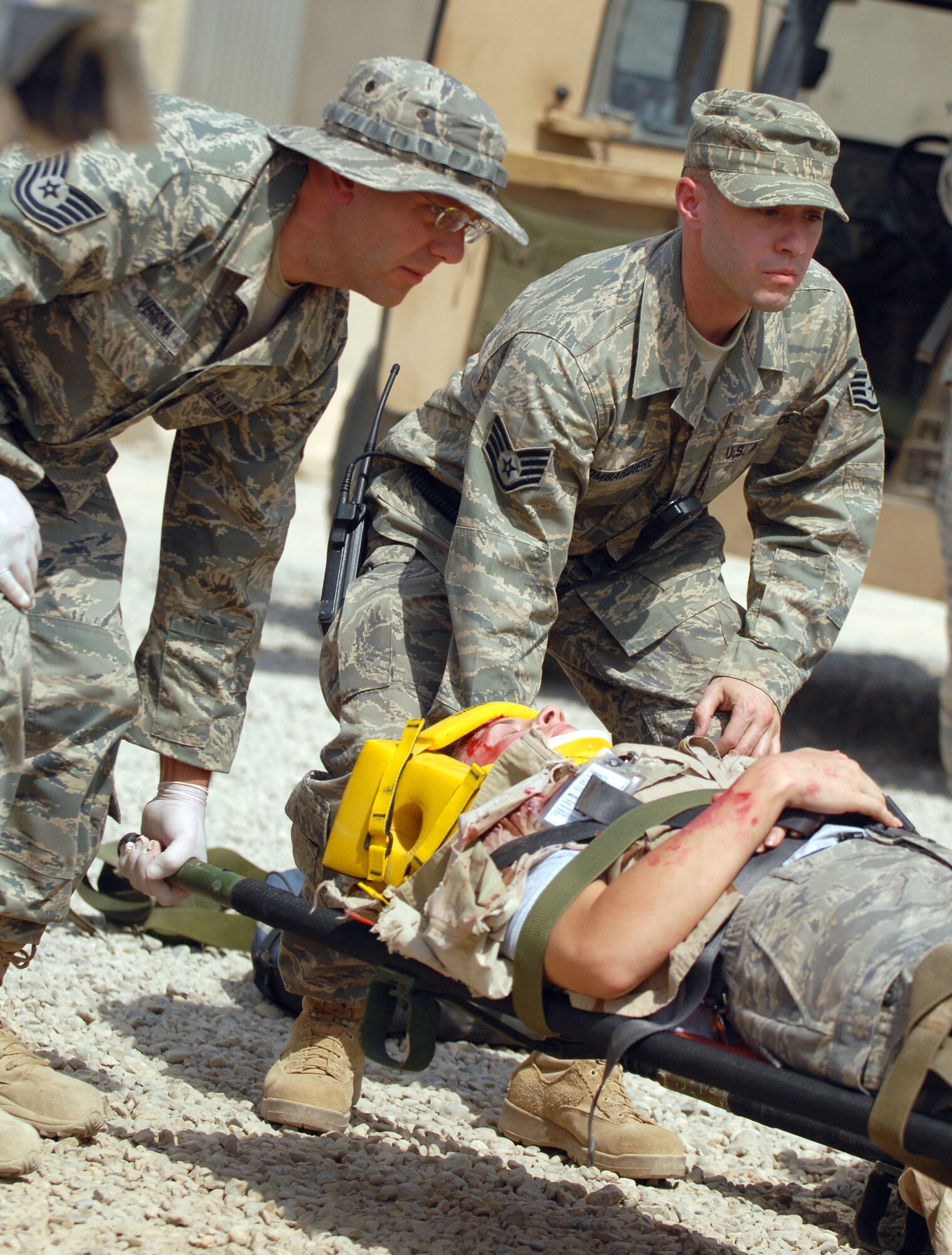 JOINT BASE BALAD, Iraq -- Tech. Sgt. Joseph Vergona and Staff Sgt. Salvatore Bombardiere carry a wounded servicemember on a stretcher during a Mass Accident Response Exercise here Aug. 11. More than 100 Airmen and Soldiers participated in the joint exercise, ensuring that first responders are ready for any situation at any time. Both NCOs are deployed to the Combat Aeromedical Staging Facility here from Pittsburgh International Airport Air Reserve Station, Penn. (U.S. Army photo/Staff Sgt. Les Newport)