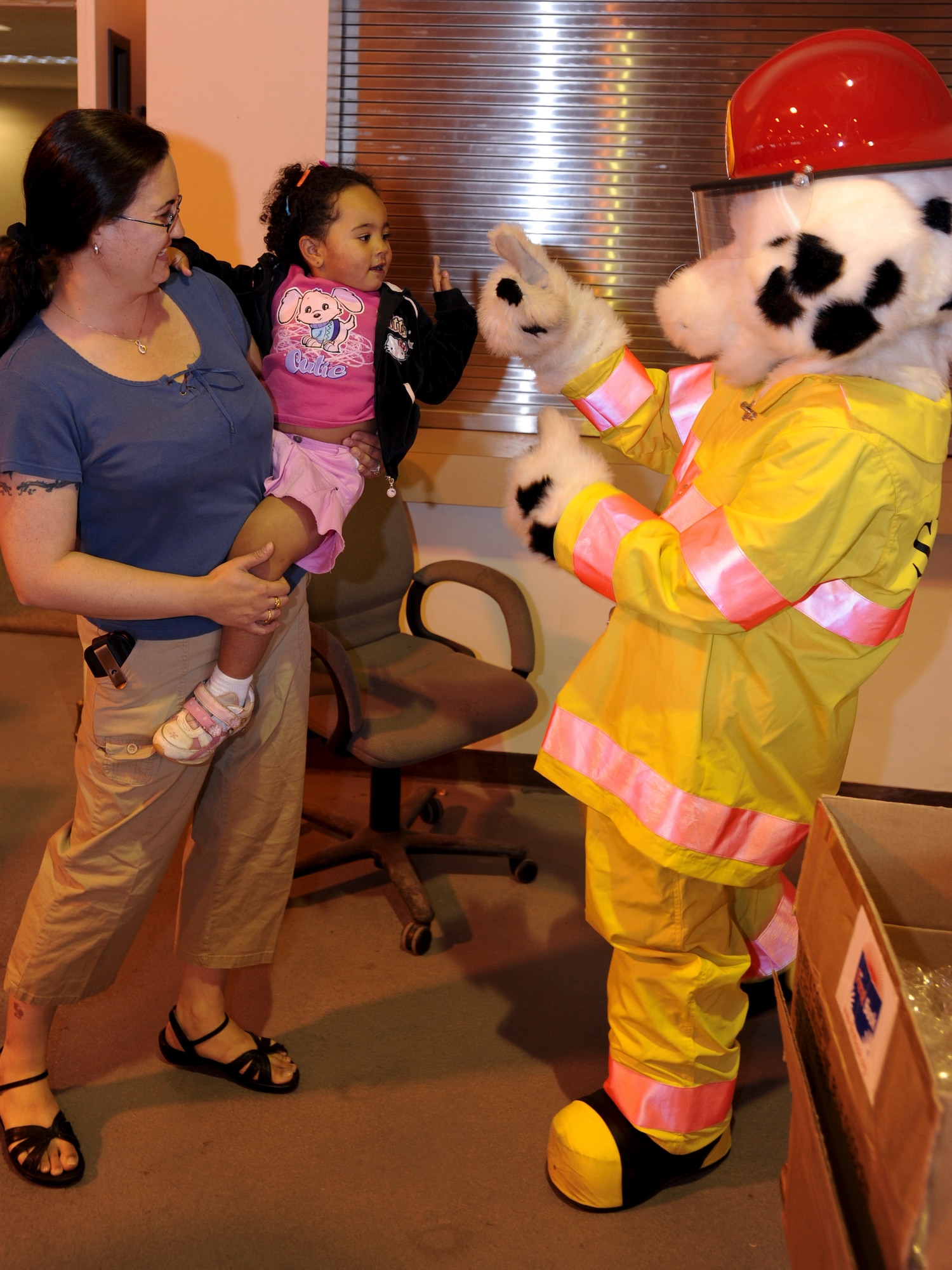 ELMENDORF AIR FORCE BASE, Alaska -- Aiko and Debra Campbell meet Sparky the Fire Dog, during Operation Topcover August 9. Sparky and members of the Fire Protection Flight, gave briefs to family members who attended the event. Operation Family Topcover allowed family members the opportunity to witness what their military members encounter prior and during their deployments. (U.S. Air Force photo/Staff Sgt. Joshua Garcia)