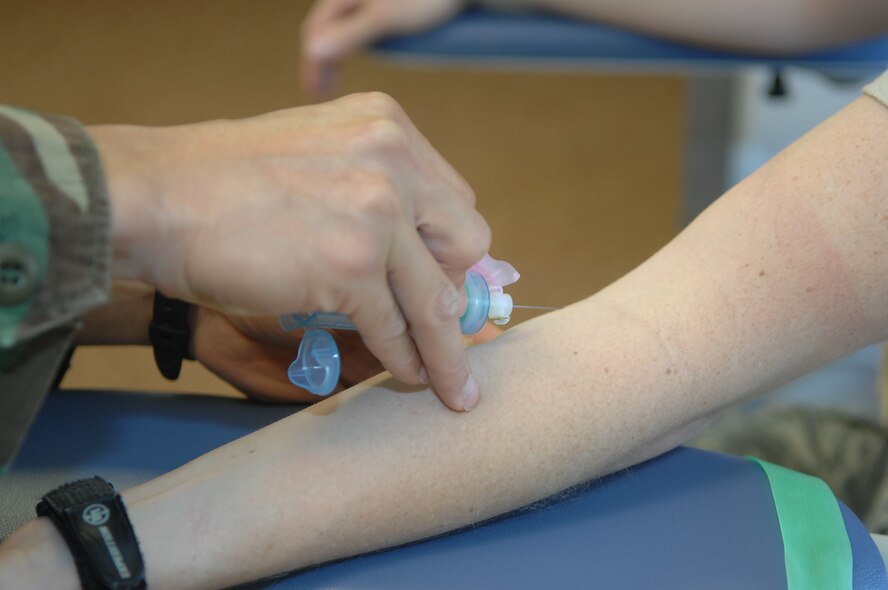 CREECH AFB, Nev. – Tech. Sgt. Nicanaor Laudato, 15th Reconnaissance Squadron, independent duty medical technician, draws blood from Staff Sgt. Courtney Schleifer, 15th Reconnaissance Squadron, medical technician, here Aug. 12. The medical aid station is now offering expanded services. (U.S. Air Force photo/Senior Airman Brian Ybarbo)