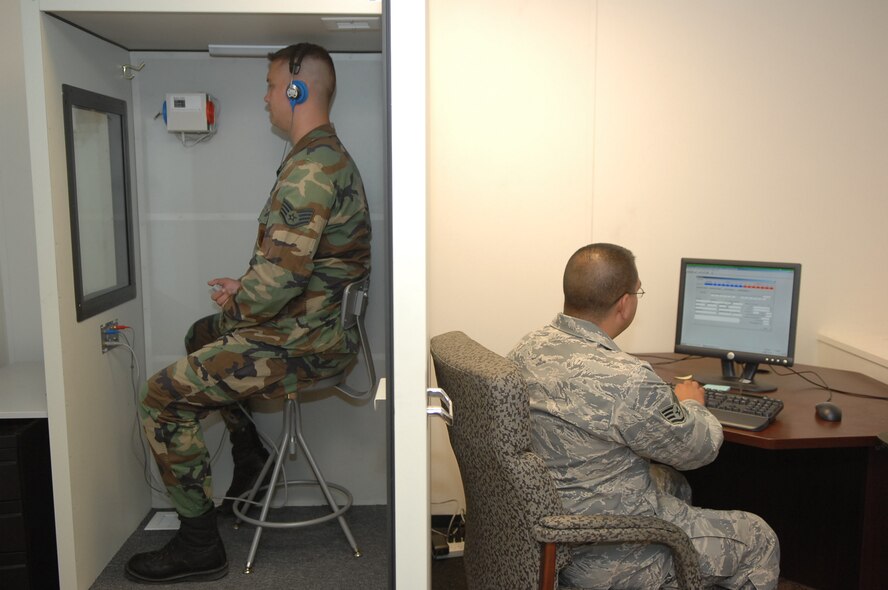 CREECH AFB, Nev. – Staff Sgt. Daniel Garcia, 15th Reconnaissance Squadron, medical technician, administers a hearing test to Staff Sgt. James Pennington 42d Attack Squadron, independent duty medical technician here Aug. 12. The hearing booth is a new addition to the expanded medical aid station here. (U.S. Air Force photo Senior Airman Brain Ybarbo) 