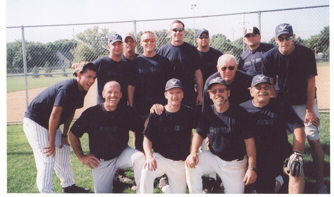 The Night Watch softball team from left to right: 
(back row) Airman 1st Class Christian Velasco, Senior Airman Wyatt Hansen, Lieutenant Commander Greg Verlinde, Senior Airman Kyle Pierce, Lieutenant Colonel (ret) George Madson, Tech Sgt Dave Troglia, Staff Sgt. Michael Dewitt, and Senior Airman Rick Northrup 
(front row) Dave Patterson, Master Sgt. (ret) Brett Stewart, Command Chief Master Sgt. (ret) Ben Heald, Lieutenant Colonel (ret) Duane Carolus, and Scott Misner. 

