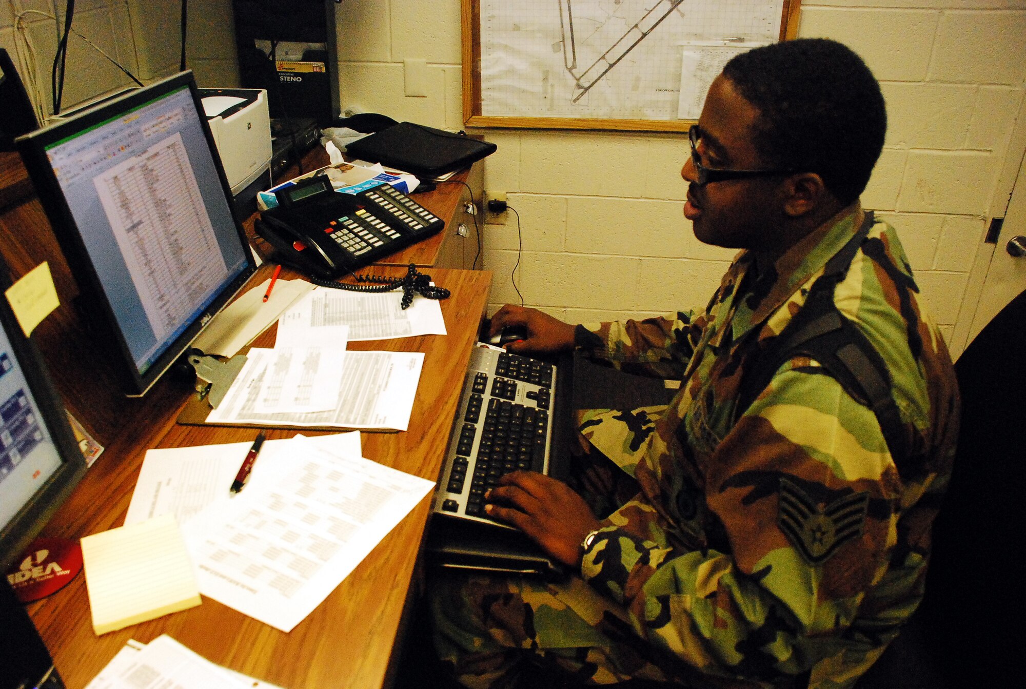 Staff Sgt. Elie Pean, 305th Security Forces Squadron patrolman and controller, works the night shift at the security forces headquarters building here Aug. 12. As an Airman, Sergeant Pean dispatches calls to fellow security forces members and keeps track of events that happen during his shift. When he’s not working security, Sergeant Pean is the president of the Marie T. Pean Foundation, in honor of his late mother, which empowers youth and local community members through education. (U.S. Air Force photo/Airman 1st Class Bekah Phy) 