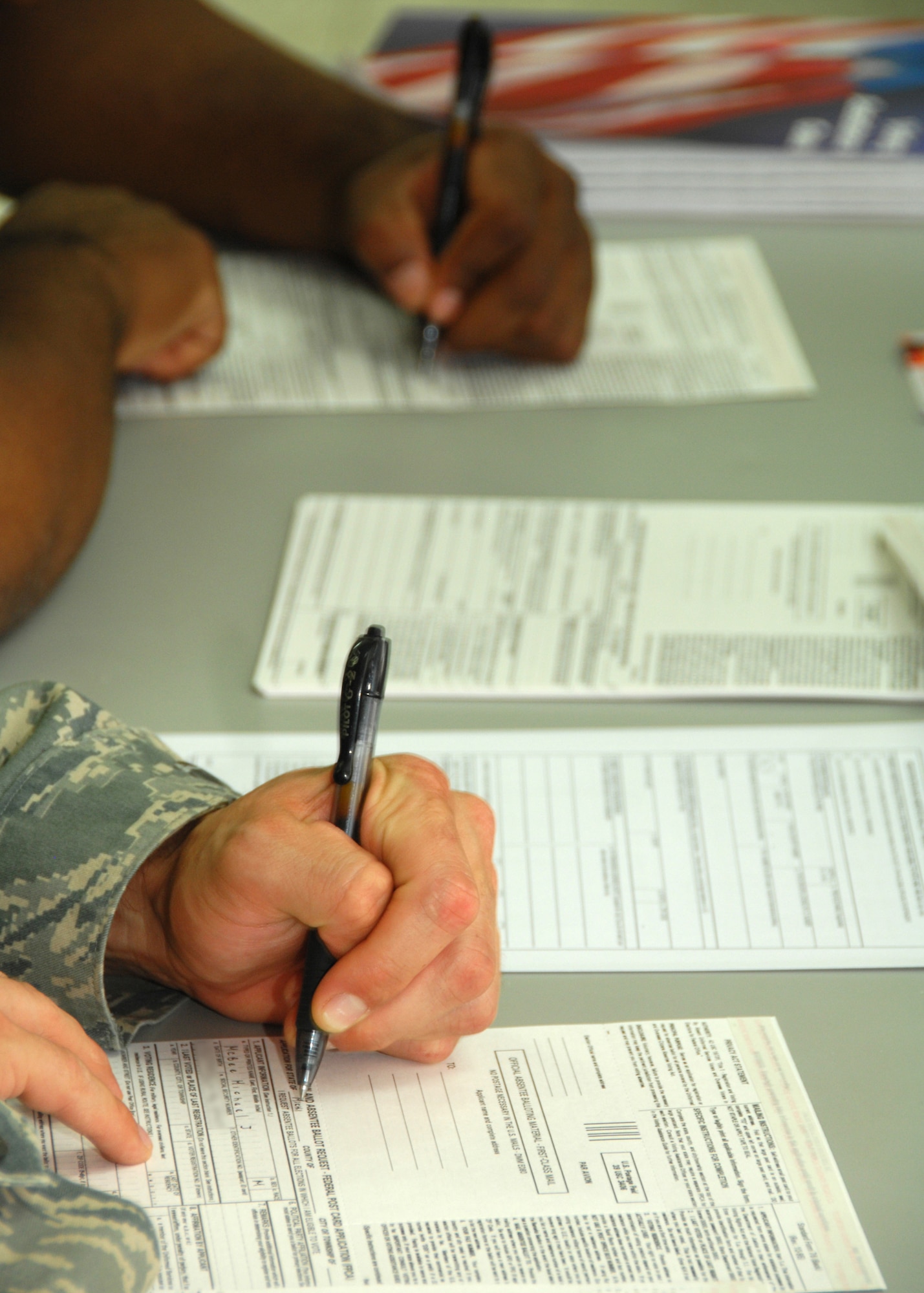 SOUTHWEST ASIA -- Army Private 1st Class Chris Williams (top) and Airman 1st Class Michael McBee register to vote on Aug. 13 at a base in Southwest Asia. The 386th Air Expeditionary Wing held a base-wide voter registration and absentee ballot drive to increase servicemember participation in November's general election.  More than 100 people signed up to become registered voters. (U.S. Air Force photo/Tech. Sgt. Raheem Moore)
