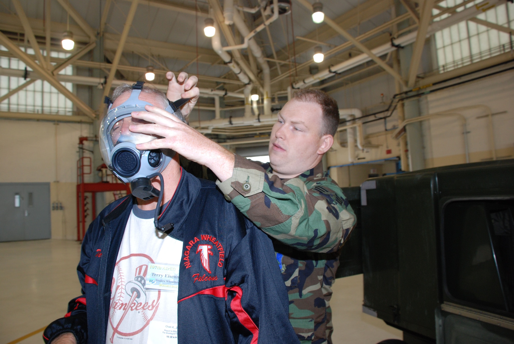 Senior Airman Shea, fits Terry Eisenman for a gas mask. Employers had the opportunity to see and try some of the equipment Airmen are issued and have to train with. (Air Force Photo/ Master Sgt. Paul Brundage)

