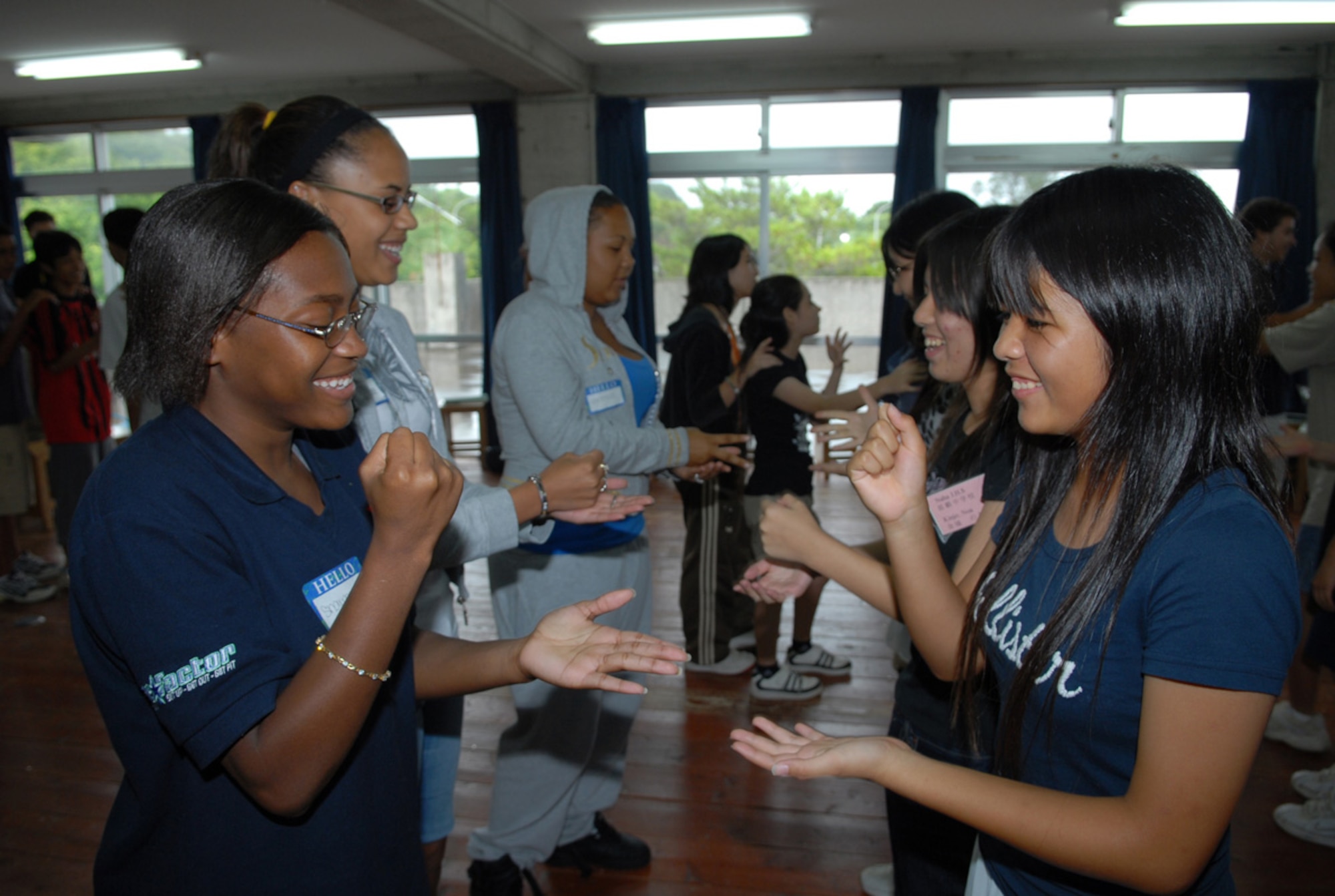 Sharmecia Andrews (left) and Arika Nikawadori play “Rock, Paper, Scissors” Aug. 7 at the Tamagusuku Youth Center. Approximately 60 American and Okinawan students participated in the cultural exchange activity. (U.S. Air Force photo/Junko Kinjo)