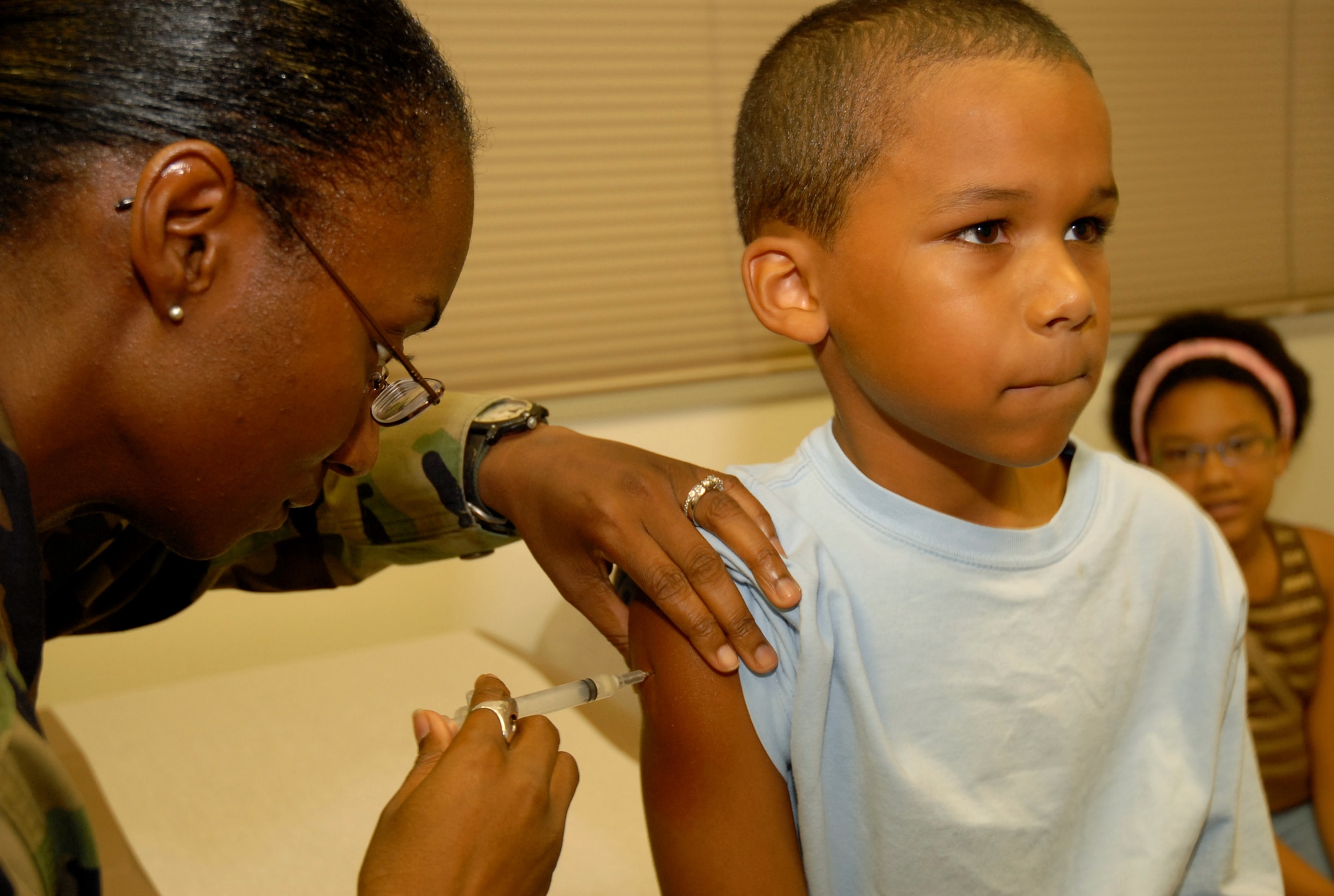 Marques Ward, 8, receives a shot by Senior Amn Alecia Peel at the Kadena Immunizations clinic.  All PACAF medical facilities are affected by the recall of the Hib vaccine and are currently experiencing an extreme shortage of the vaccination. 
(U.S. Air Force photo by Staff Sergeant Angelique M. Perez)