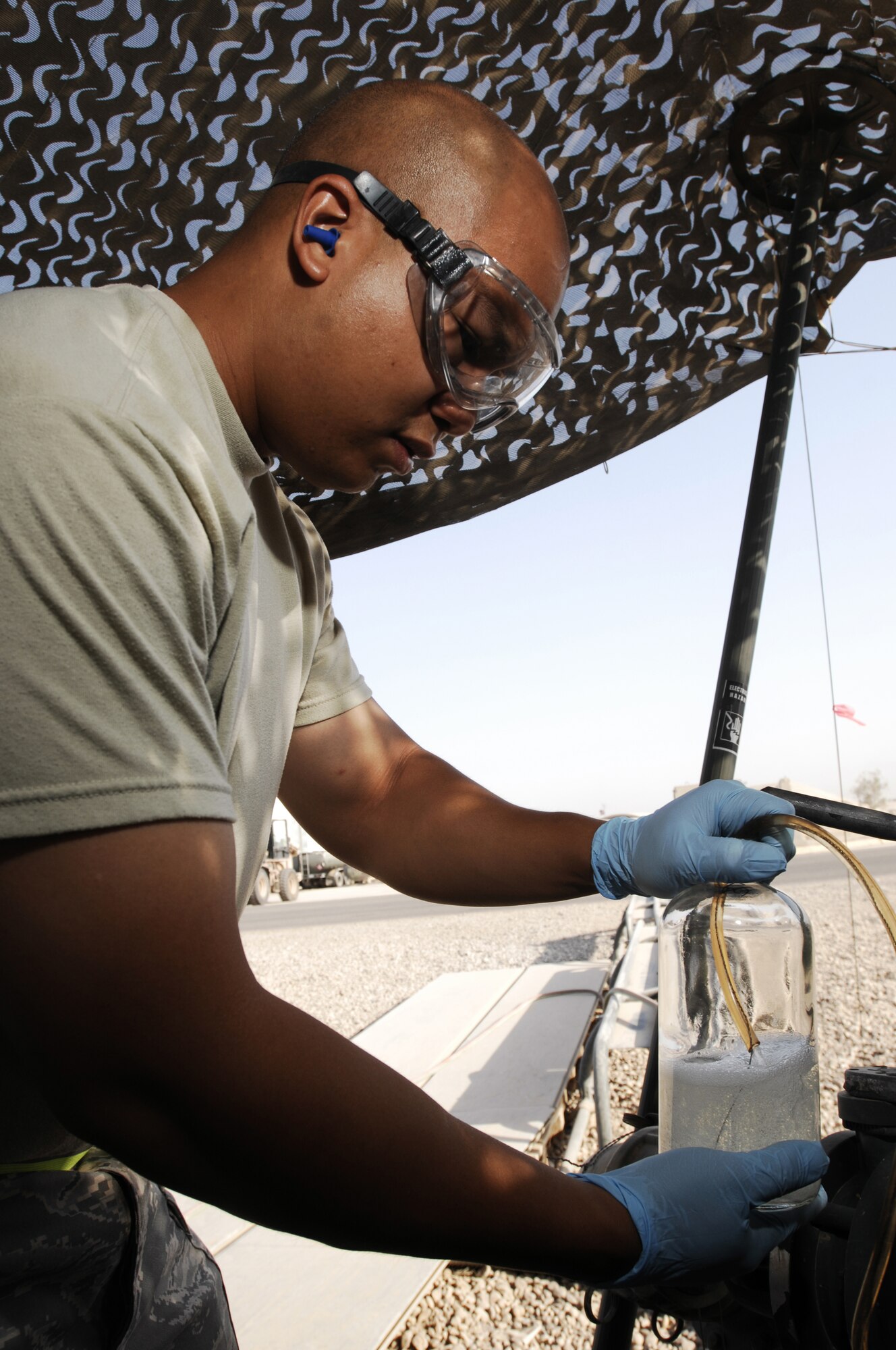 JOINT BASE BALAD, Iraq -- Staff Sgt. Benjamin Laguana collects a fuel sample from a storage bladder here Aug. 12. The fuel is checked regularly to ensure no contaminants are present. Sergeant Laguana, a fuels laboratory technician with the 332nd Expeditionary Logistics Readiness Squadron here, is deployed from Holloman Air Force Base, N.M. His hometown is Long Beach, Calif. (U.S. Air Force photo/Airman 1st Class Jason Epley)