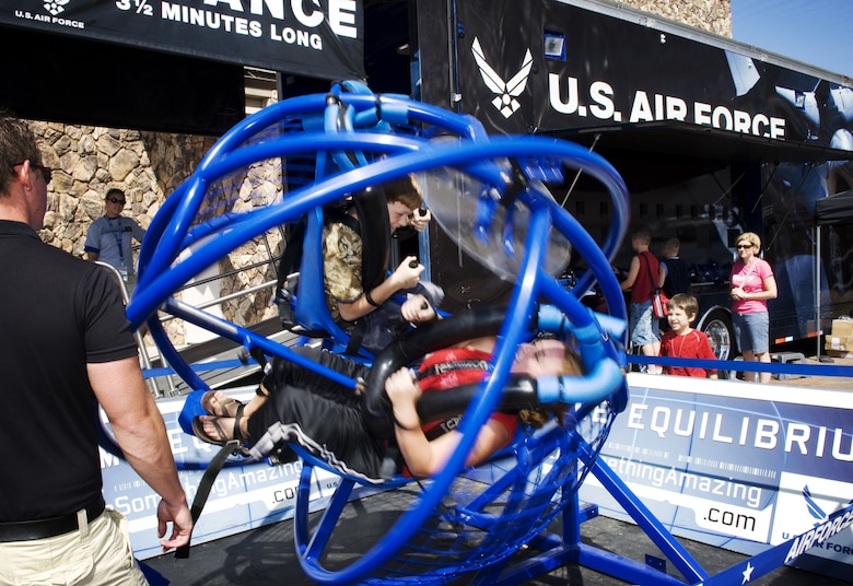 Abi and Dean Finley ride the Extreme Equilibrium device at the Do Something Amazing display Aug. 12 at the Henry Doorly Zoo in Omaha, Neb. Zoo visitors had a chance to see an F-16 Fighter Falcon, a motion simulator, video simulators and Air Force Honor Guard drill team performances. (U.S. Air Force photo/Lance Cheung)