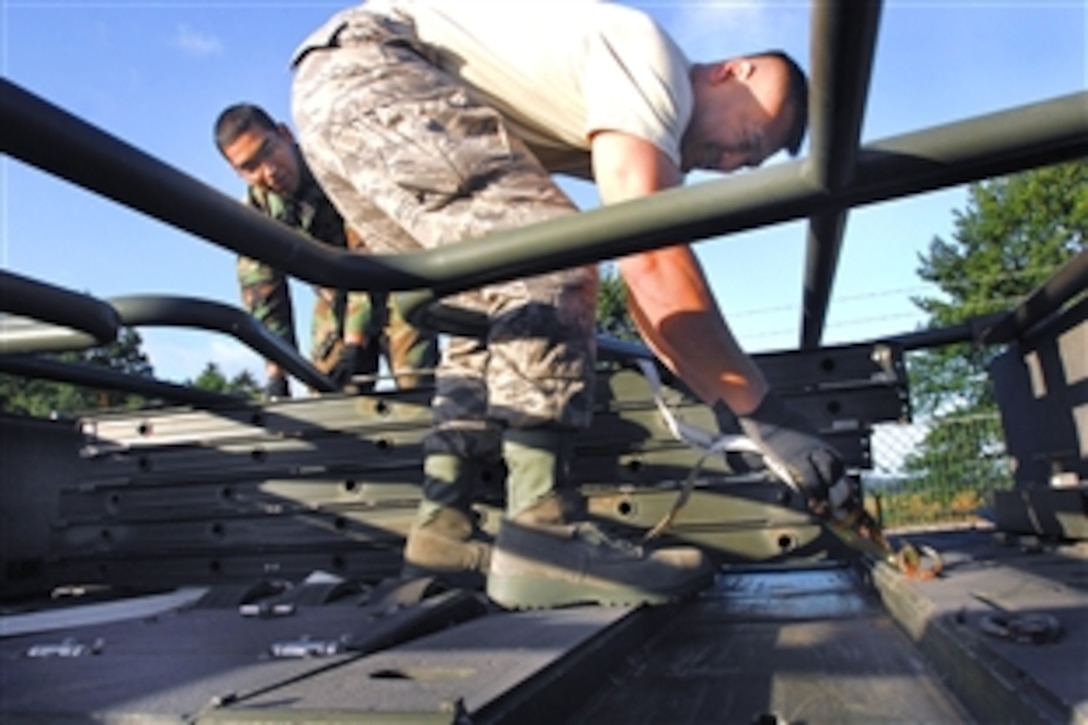 U.S. Air Force Master Sgt. Seksun Monroe, right, and Airman 1st Class Rogelio Munoz prepare cargo to be sent to Georgia from Ramstein Air Base, Germany, Aug. 13, 2008. Monroe and Munoz are assigned to the 435th Logistics Readiness Squadron. 