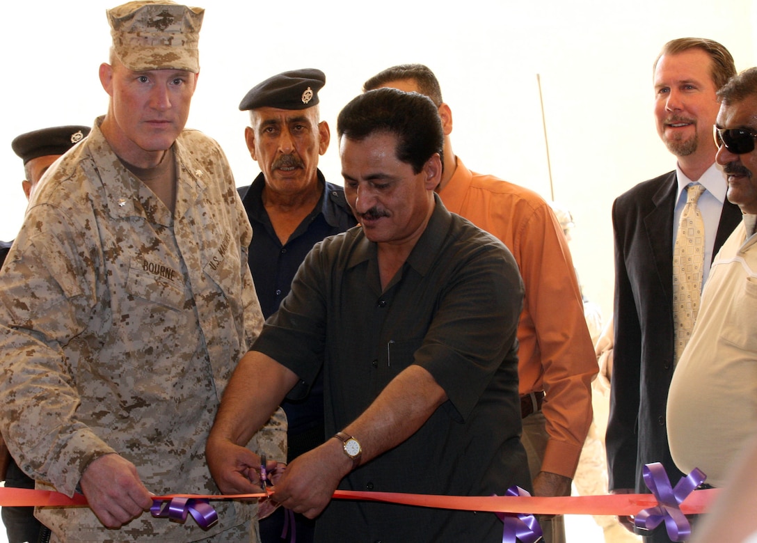 RAMADI, Iraq (August 15, 2008) – (center) Khalid Abdul Salam, an assistant to the Director General of Schools and (left) Lt. Col. Brett A. Bourne, the commanding officer of 1st Battalion, 9th Marine Regiment, Regimental Combat Team 1, cut a ribbon signaling the reopening of the Industrial High School August 13. The Industrial High School in Ramadi was the latest school to open in the city. "It’s great that the city was able to get this school opened up,” said Khalid Abdul Salam; an assistant to the Director General of Schools. “The school is going to be a wonderful institution not only for the students but for all of Ramadi. As the youth of the city continue to earn an education, they will assist the city and the province in making their country prosperous.” (Official U.S. Marine Corps photo by Lance Cpl. Casey Jones) (RELEASED)