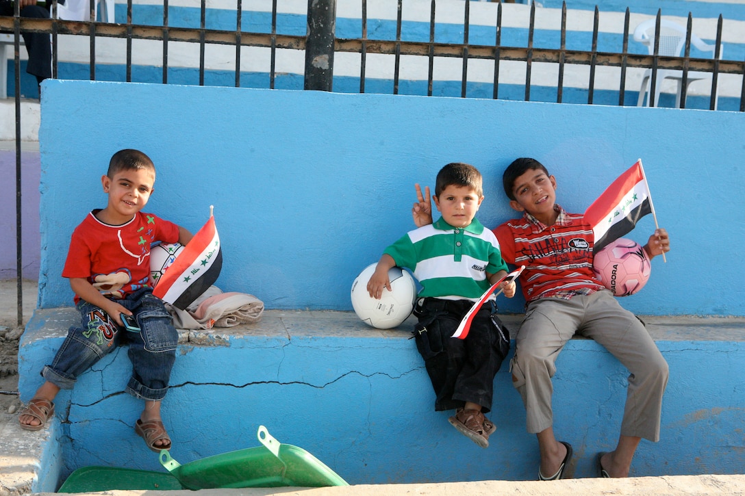 RAMADI, Iraq (August 13, 2008) - Iraqi children pose for a photo as Iraqi’s play a game of soccer during the Ramadi Soccer Tournament at the Mulaab Soccer Stadium August 10. The tournament involved 10 teams from various neighborhoods in the city. The event was featured two elimination-style games played each night until a winner was determined. (Official U.S. Marine Corps photo by Staff Sgt. Joshua S. Higgins) (RELEASED)