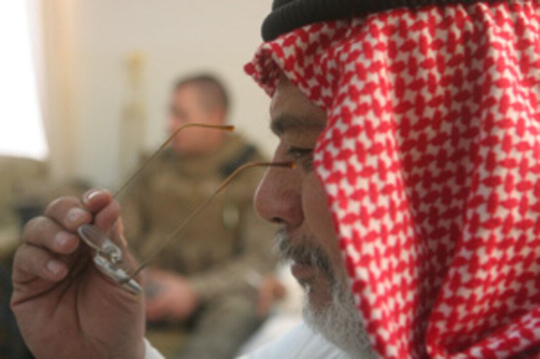 Hamed Khalid Abrahim, the mayor of Rawah, Iraq, tries on a new pair of glasses in Rawah Aug 13. Coalition forces delivered 720 pairs of prescription glasses to the local optometrist in Rawah. The glasses were donated by three organizations from Colorado: the Fort Collins Lions Club, the Sterling Lions Club and the Rotary Club of Fort Collins.  The glasses will be made available to residents of Rawah who need them and could otherwise not afford them::r::::n::