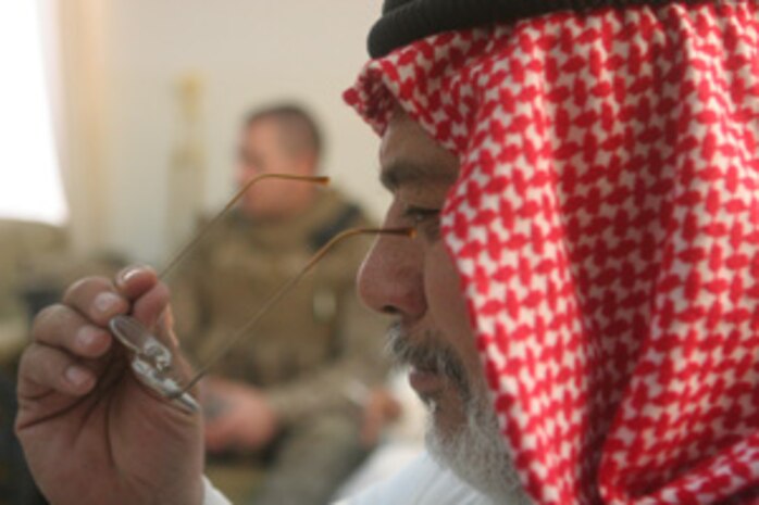 Hamed Khalid Abrahim, the mayor of Rawah, Iraq, tries on a new pair of glasses in Rawah Aug 13. Coalition forces delivered 720 pairs of prescription glasses to the local optometrist in Rawah. The glasses were donated by three organizations from Colorado: the Fort Collins Lions Club, the Sterling Lions Club and the Rotary Club of Fort Collins.  The glasses will be made available to residents of Rawah who need them and could otherwise not afford them::r::::n::