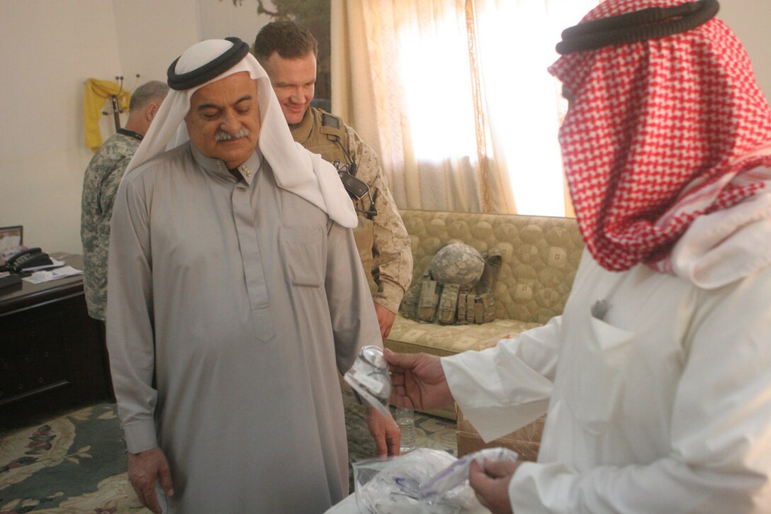 Hamed Khalid Abrahim, the mayor of Rawah, Iraq, and Isam Khamis Theb, who is the city council chairman, look through the boxes of glasses that Marines delivered to their office. Coalition forces delivered over 700 pairs of prescription glasses to the local optometrist in Rawah. The glasses were donated by three organizations from Colorado: the Fort Collins Lions Club, the Sterling Lions Club and the Rotary Club of Fort Collins.::r::::n::