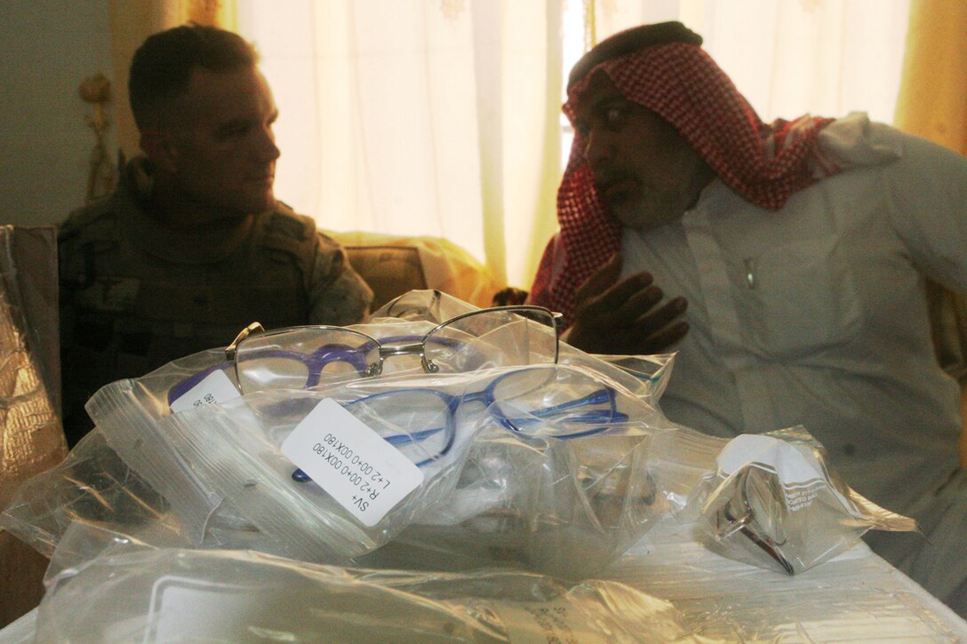 Hamed Khalid Abrahim, the Mayor of Rawah, Iraq, and navy Lt. Malcolm Brown, 38, from Fort Collins Colo., who is the battalion surgeon for 2nd Battalion, 2nd Marine Regiment, Regimental Combat Team 5, discuss how prescription glasses will be distributed among the people of Rawah. Over 700 glasses were donated by three organizations from Colorado: the Fort Collins Lions Club, the Sterling Lions Club and the Rotary Club of Fort Collins.  The local clinic in Rawah did not have enough glasses to support the needs of the residents.::r::::n::