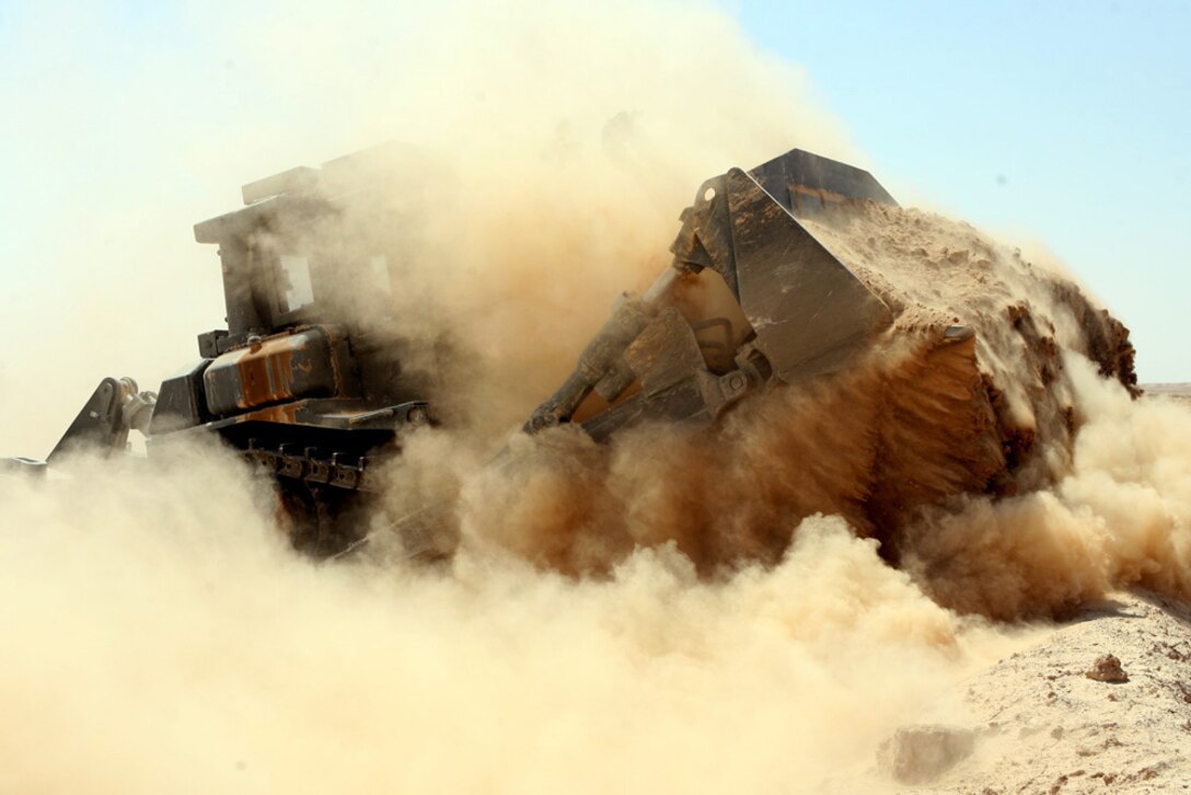 A bulldozer pushes up dirt to create a berm Aug. 13 along the Iraq and Syrian border. Approximately 30,000 yards of berm were created during an almost two-week-long mission. Marines with Support Platoon, Company A, 3rd Combat Engineer Battalion, Regimental Combat Team 5 surveyed the entire border, filling in gaps on the berm in order to prevent people from crossing the border illegally.