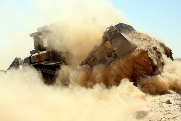 A bulldozer pushes up dirt to create a berm Aug. 13 along the Iraq and Syrian border. Approximately 30,000 yards of berm were created during an almost two-week-long mission. Marines with Support Platoon, Company A, 3rd Combat Engineer Battalion, Regimental Combat Team 5 surveyed the entire border, filling in gaps on the berm in order to prevent people from crossing the border illegally.