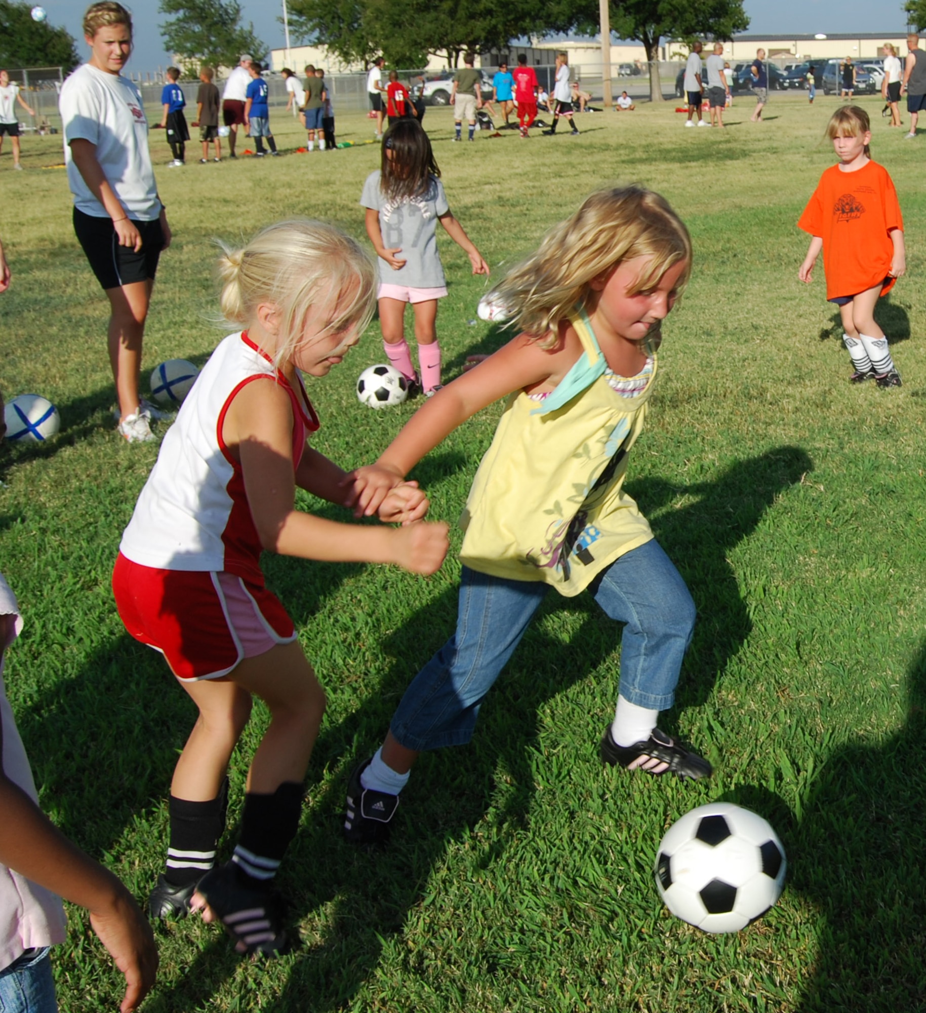 Adrienne Pritchard, 5, steals the ball from Kalea Hahm, 6, at the Madrigal Youth Center Soccer Clinic for Kids Aug.14. The clinic was held as a practice session to prepare for the fall soccer season. Members of the Midwestern State University Girls Soccer Team helped the children practice various soccer drills and techniques. (U.S. Air Force photo/Airman 1st Class Candy Miller) 