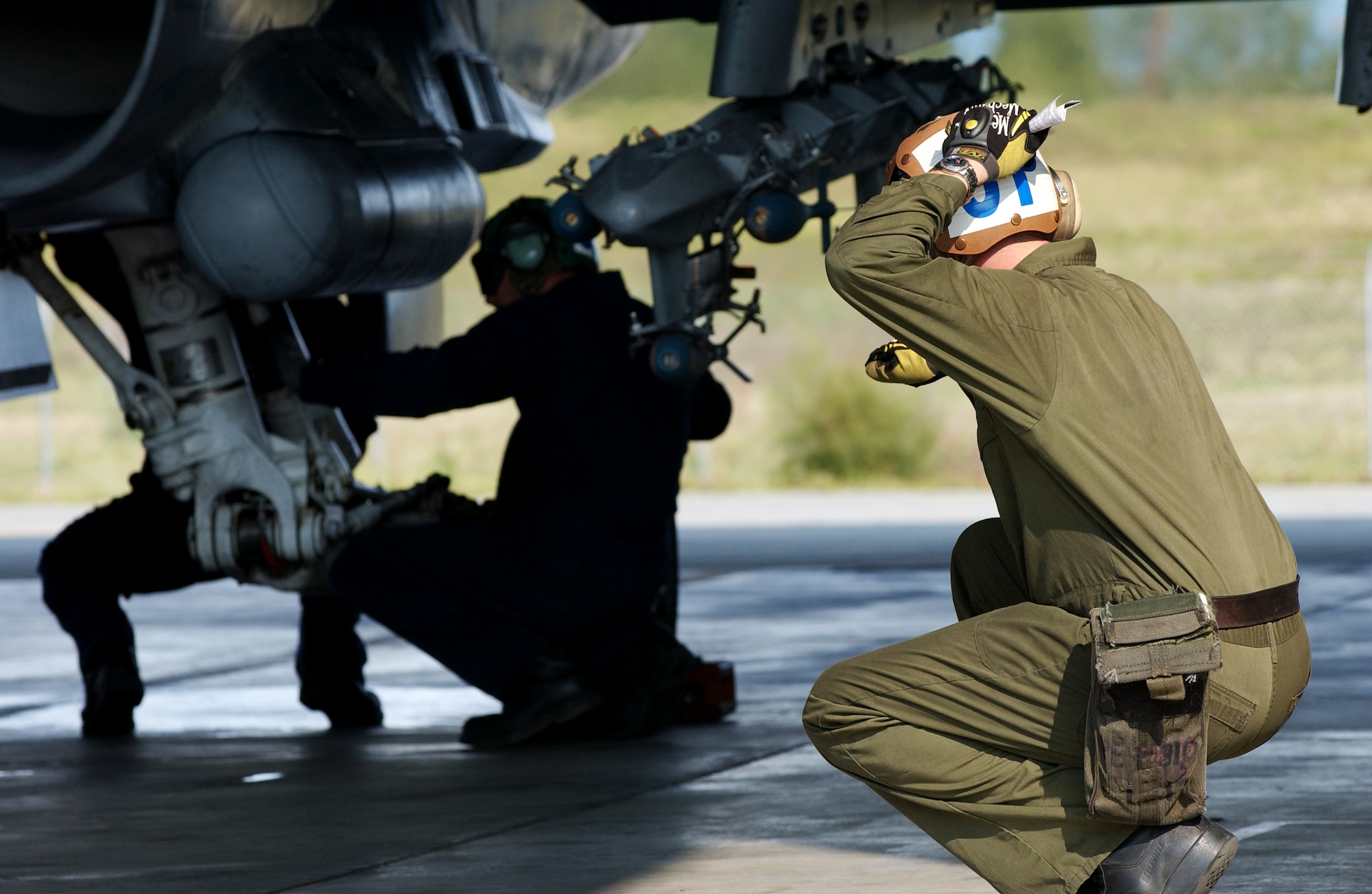 Aviation Mechanic Dennis Crawford motions to the pilot that there are other people under the F/A-18 Hornet conducting pre-flight inspection Aug 13, 2008 at Eielson Air Force Base, Alaska. Navy Strike Fighter Squadron 125, based out of Naval Air Station Lemoore, Calif., is currently conducting air to ground target training here by utilizing the 67,000 square mile Pacific Alaskan Range Complex. During this training new fighter pilots are gaining the qualification they need before they are sent to the fleet. Seaman Crawford is assigned to the VFA-125 Squadron Augment Unit.  (U.S. Air Force photo by Airman 1st Class Jonathan Snyder)